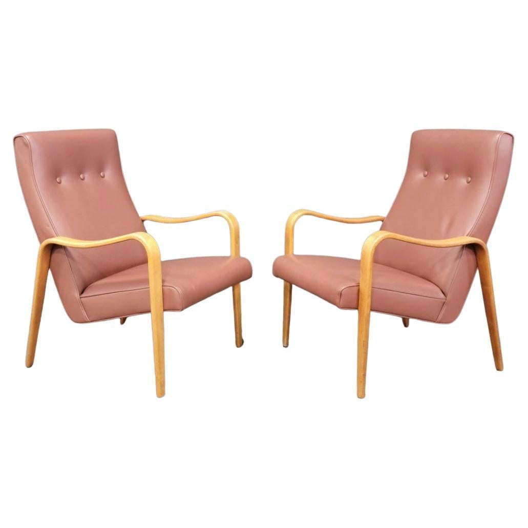 Pair of Mid-Century Modern Thonet bentwood birch lounge arm chairs. Has original medium pastel pinkish vinyl upholstery. Great vintage condition. Timeless chair design by Thonet. Curved birch bentwood arms. Chairs sold as a set of (2). Located in