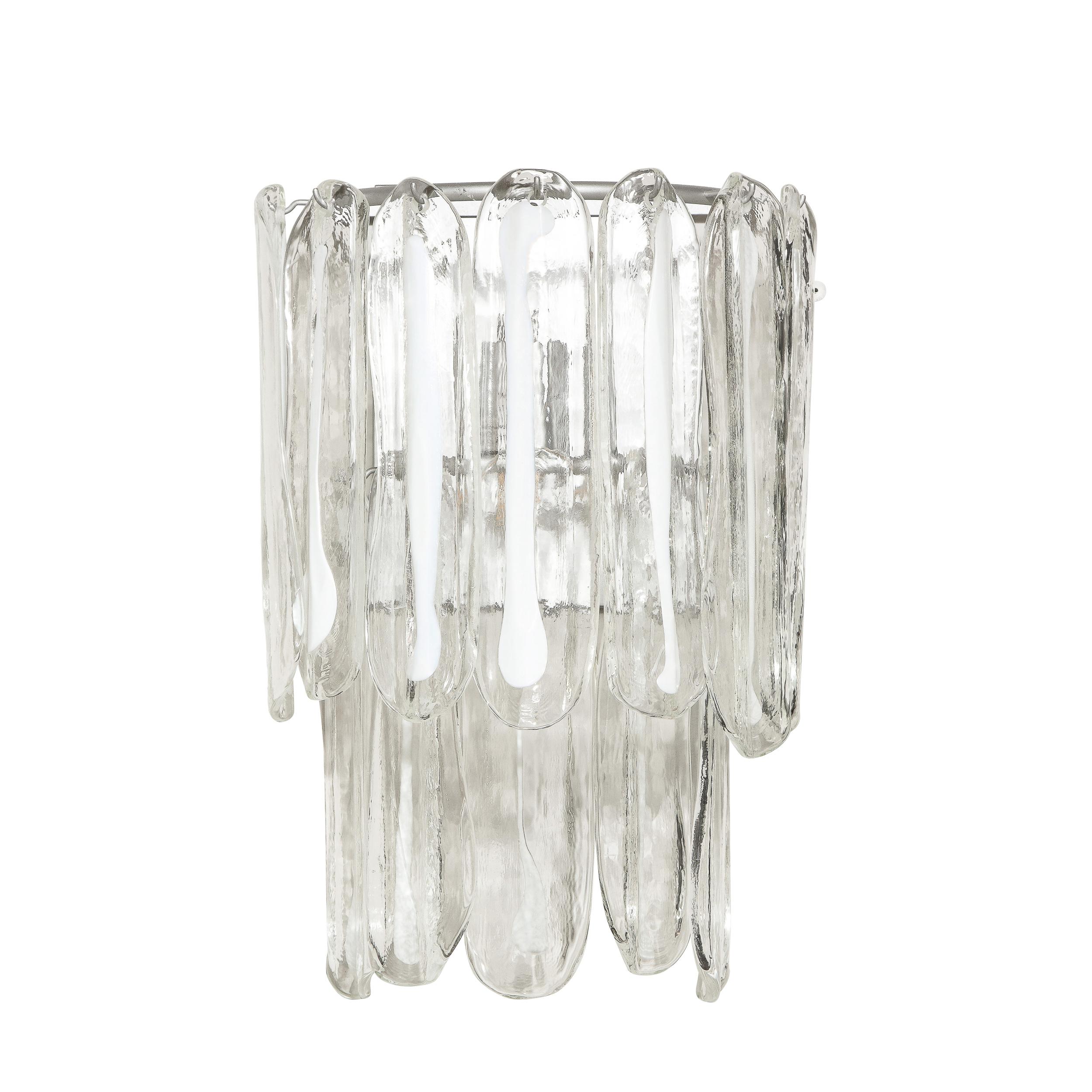 This elegant pair of Mid-Century Modern sconces were realized by the esteemed Italian maker Mazzega in Murano, Italy circa 1970. They feature ovoid shades in translucent Murano glass with white opaque centers attached to a lustrous chrome frame.