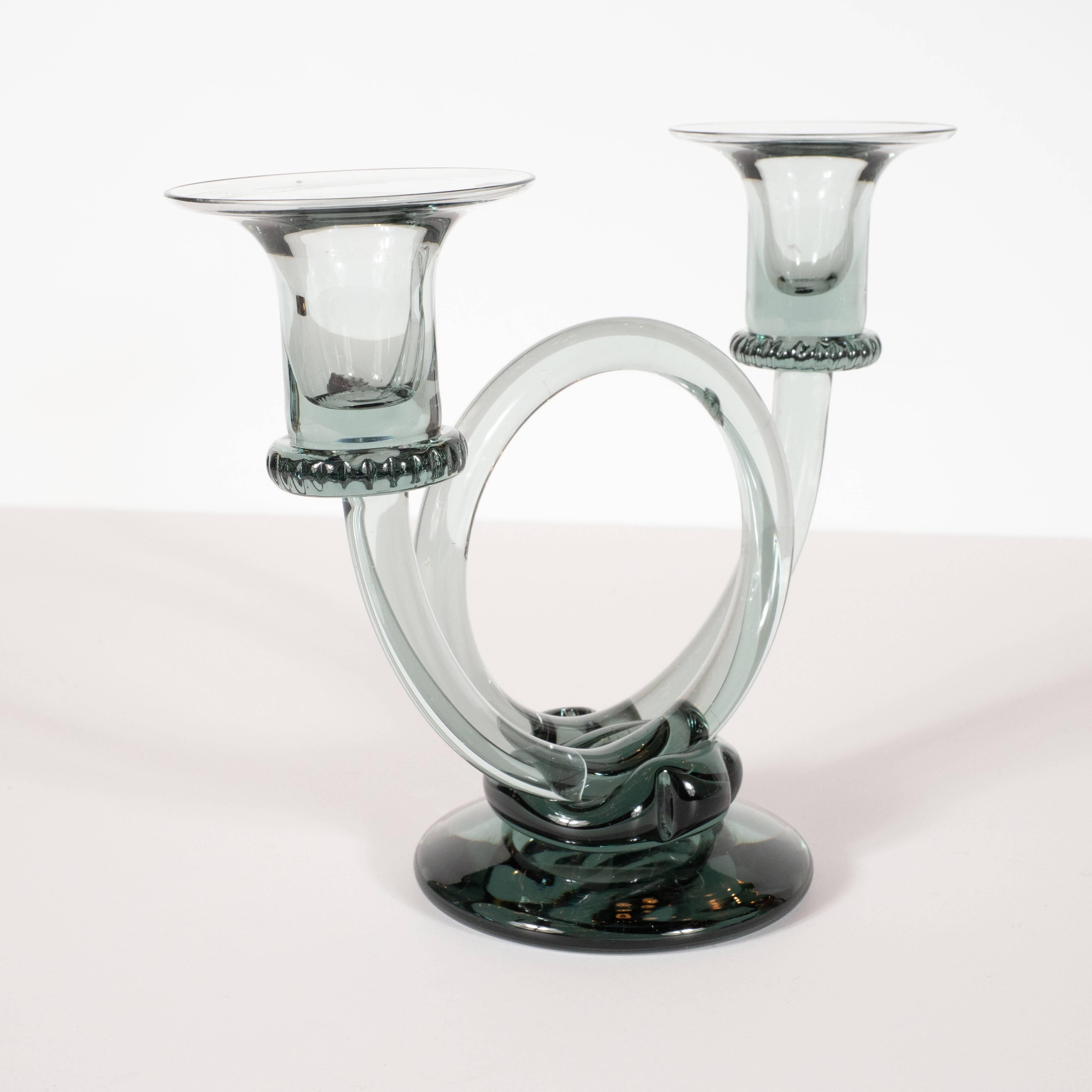 This elegant pair of candlesticks were designed by A.D Copier and handblown by the Royal Leerdam Glassworks in the Netherlands- circa 1950. They feature two trumpet form candlesticks composed of a single curling cylindrical rod that creates a