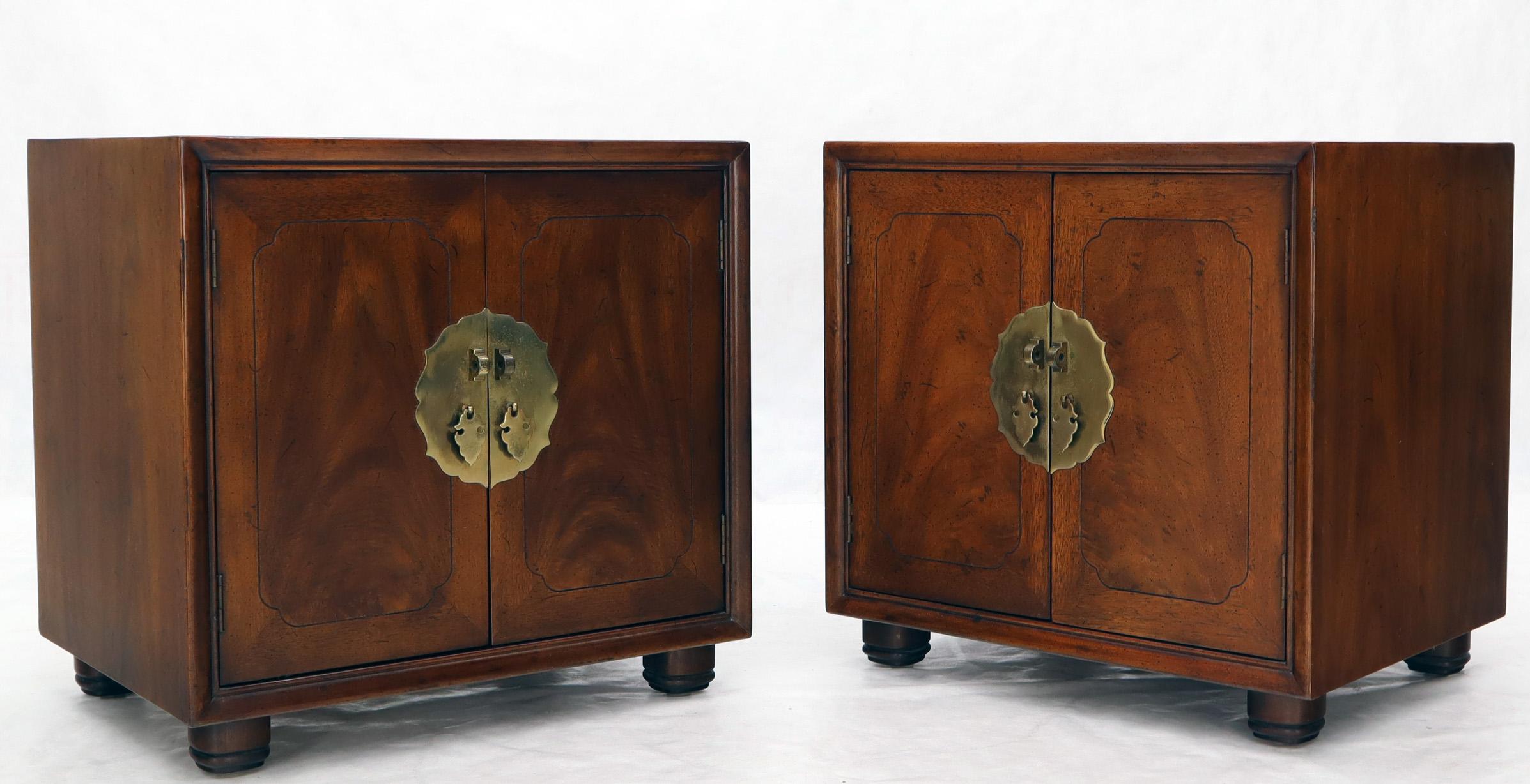 Pair of Mid-Century Modern nightstands tables by Henredon in medium walnut finish. Featuring large decorative brass hardware section with pulls.
