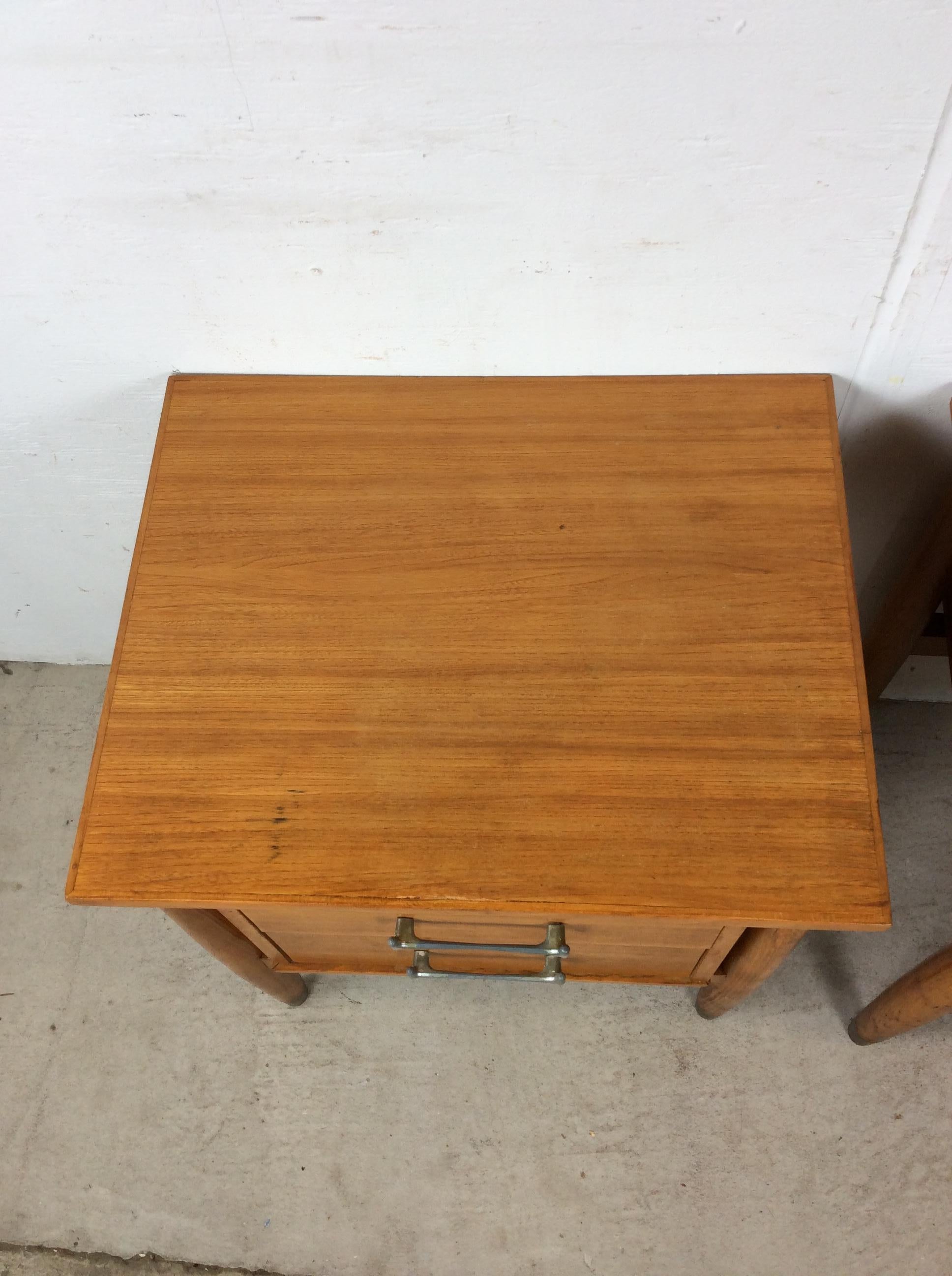 This pair of mid century modern nightstands by Milo Baughman for Drexel feature hardwood construction, maple veneer with original finish, newly refinished tops, two dovetailed drawers with chrome hardware, and tall tapered legs with brass capped