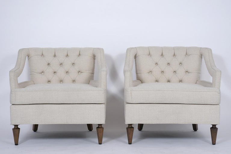 An extraordinary of 1960s midcentury lounge chairs have been completely restored and feature a stylish curved back and open arm design. These club chairs have been professionally upholstered in beige color fabric tufted design with single piping