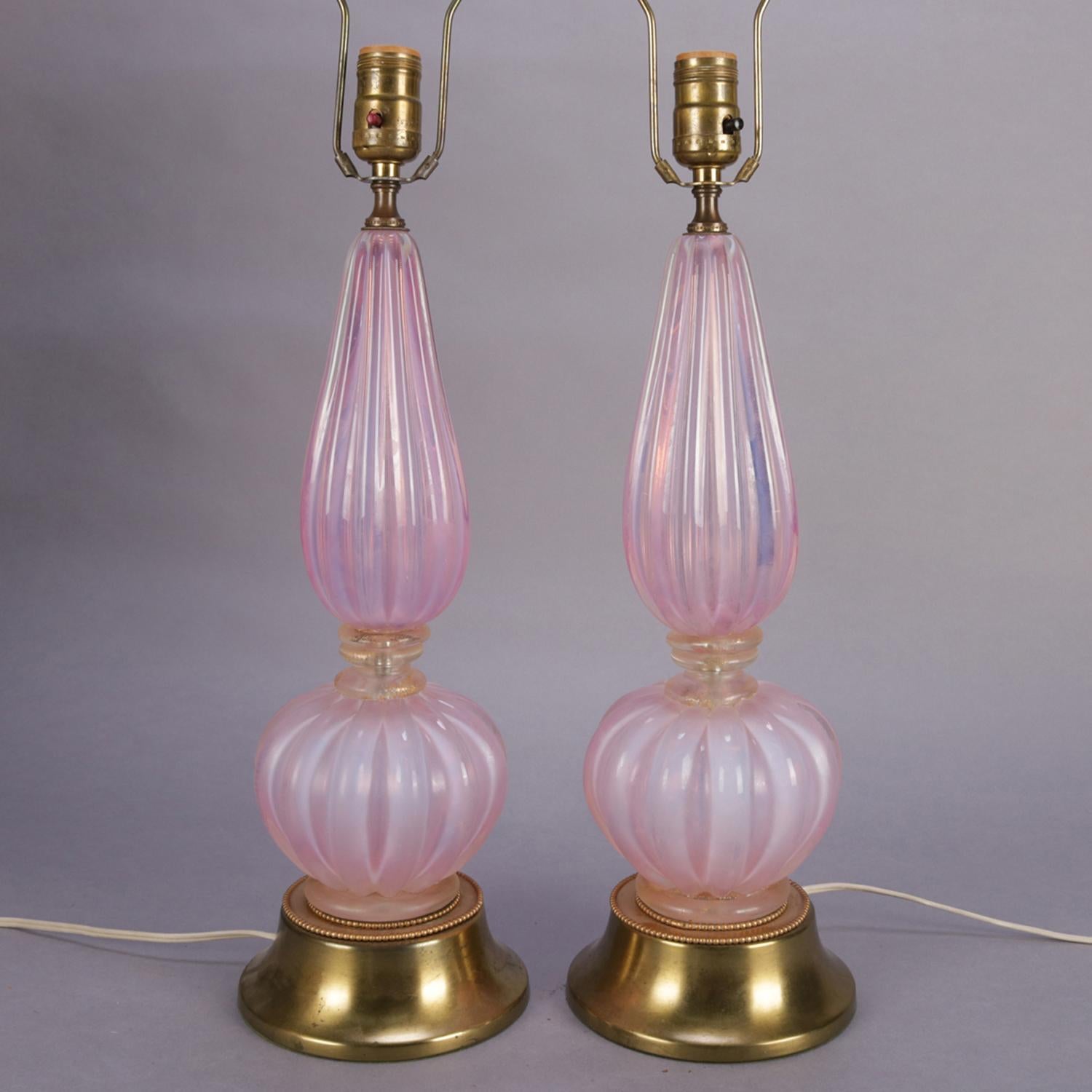 A pair of Mid-Century Modern table lamps feature pink opalescent Venetian Murano glass vases in gourd form with gilt at waists and are seated on brass base, circa 1960.

Measures: 31