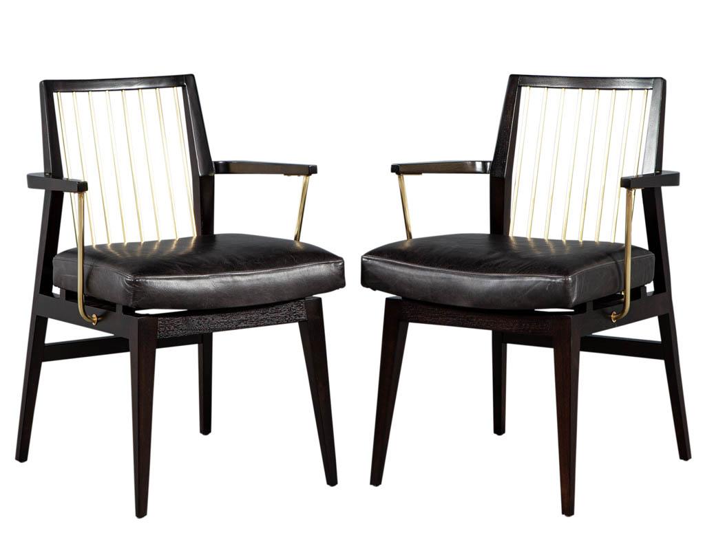 Pair of Mid-Century Modern vintage leather arm chairs with brass accents. Unique brass features with rich dark espresso finish. Completed with newly upholstered leather seats. Chairs are in excellent original condition, brass has very minor wear