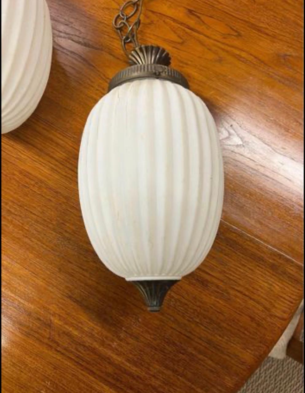 Pair of mid century modern milk glass hanging swag lights. Untested. Removed from original owner's home last year.
The lamps measure 7