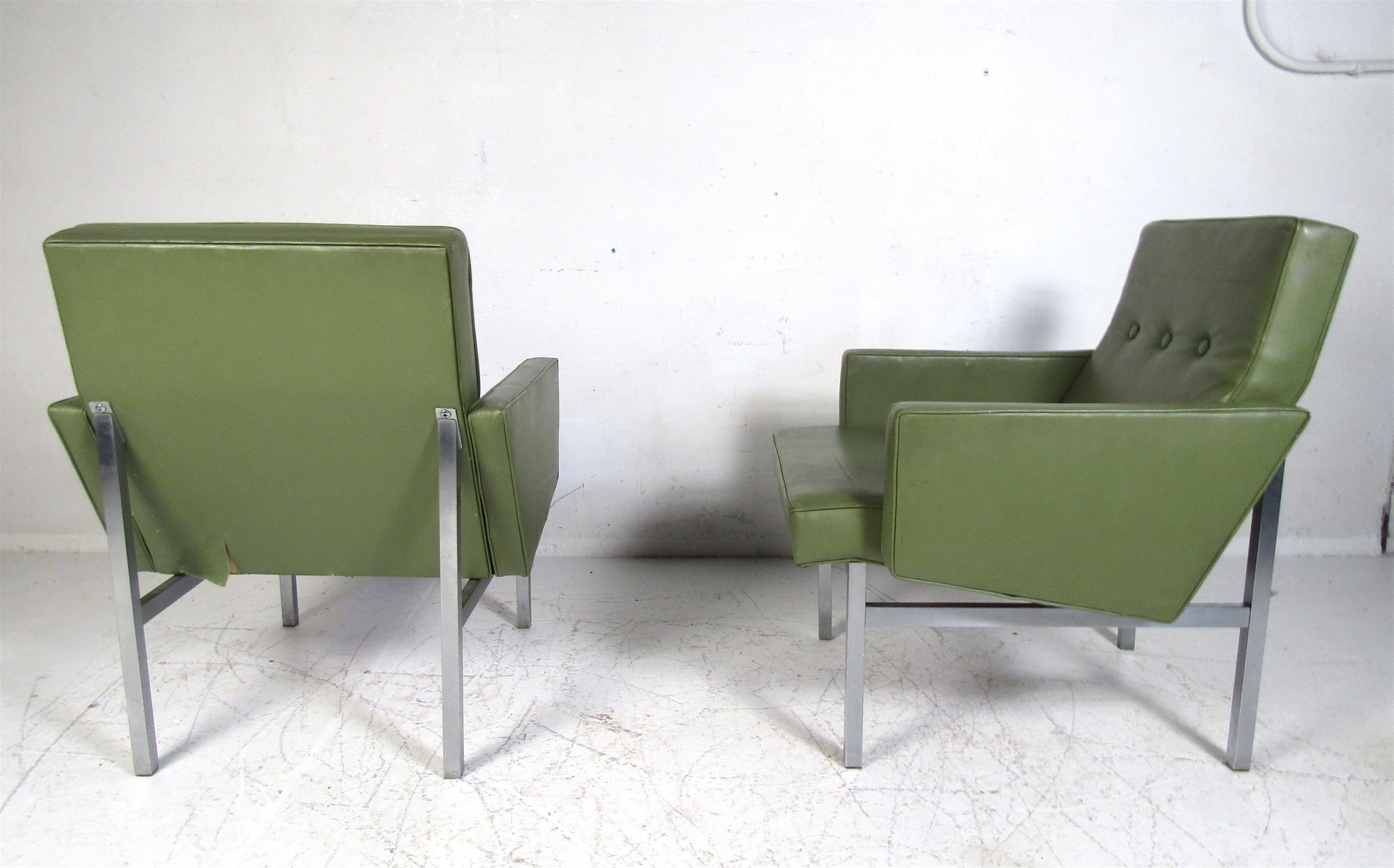 A beautiful pair of vintage modern armchairs with metal legs and tufted green vinyl upholstery. The wonderful design offers maximum comfort without sacrificing style. A perfect addition to any home, business, or office. Please confirm the item