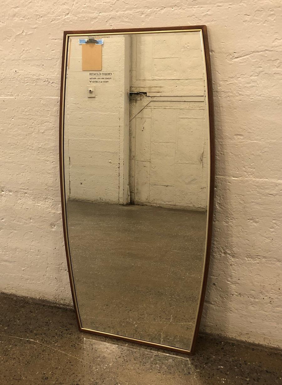 Pair of Mid-Century Modern, solid walnut framed mirrors. The mirrors are beveled with brass trim.