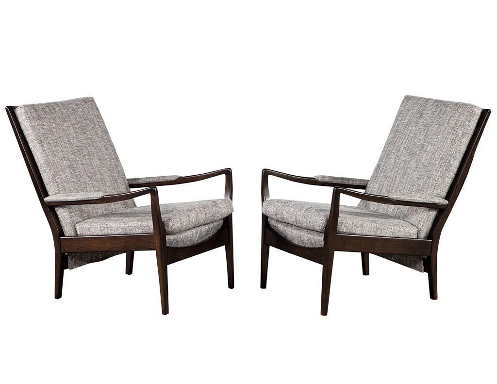 Pair of Mid-Century Modern walnut lounge chairs. America circa 1970’s, iconic Mid-Century Modern styling. Beautiful curves and unique shape. Masterfully restored in a rich dark espresso walnut and all new upholstery work. Fabric features beautiful
