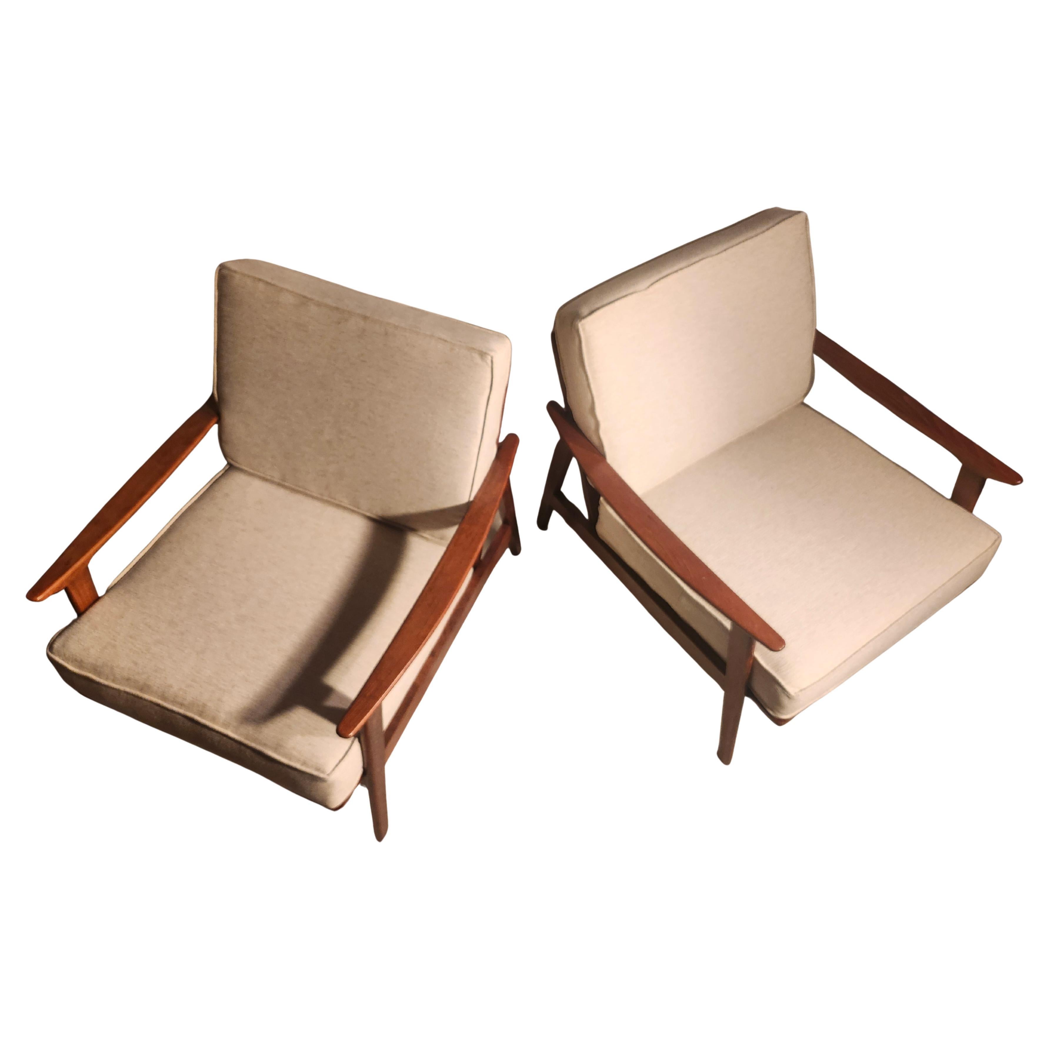 Fabulous pair of Mid Century Modern sculptural solid walnut longe chairs with long sloping arms. Brand new cushions custom made for the pair. Wood was restored to its natural beauty, professionally. Spring tension straps are original and in