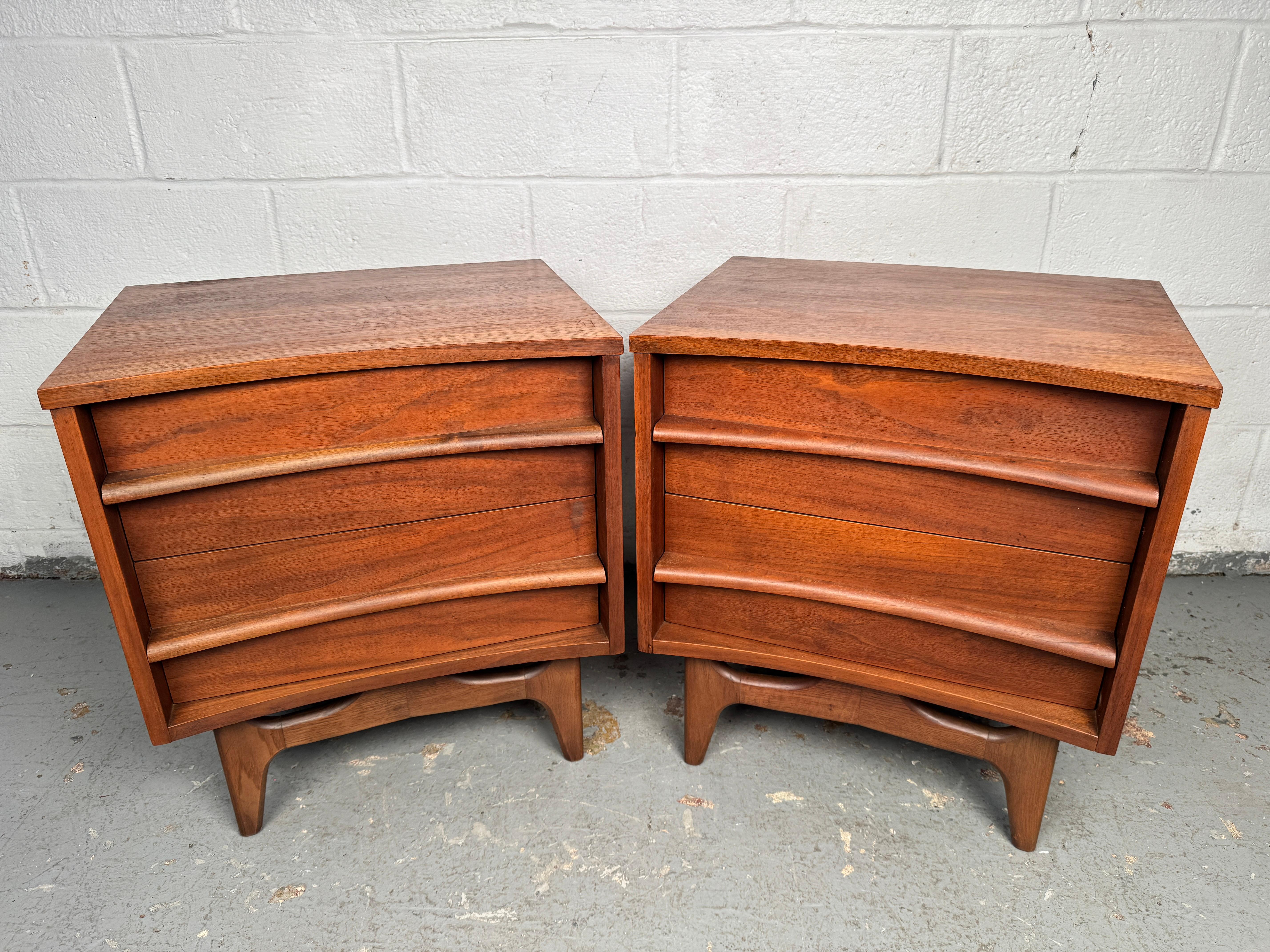 Elegante coppia di comodini MCM realizzati da Young Manufacturing Company. Pezzi in noce caldo caratterizzati da linee pulite e da un pratico spazio di archiviazione. Compatti ma eleganti, sono perfetti come comodini o come versatili tavolini. Un