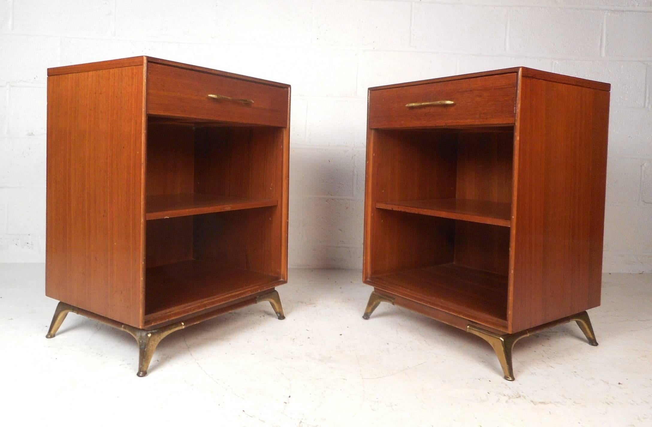 This gorgeous pair of vintage modern nightstands feature splayed brass legs and sculpted brass drawer pulls. The sleek design offers plenty of room for storage with one hefty drawer and a large compartment with a shelf. Sturdy construction with a