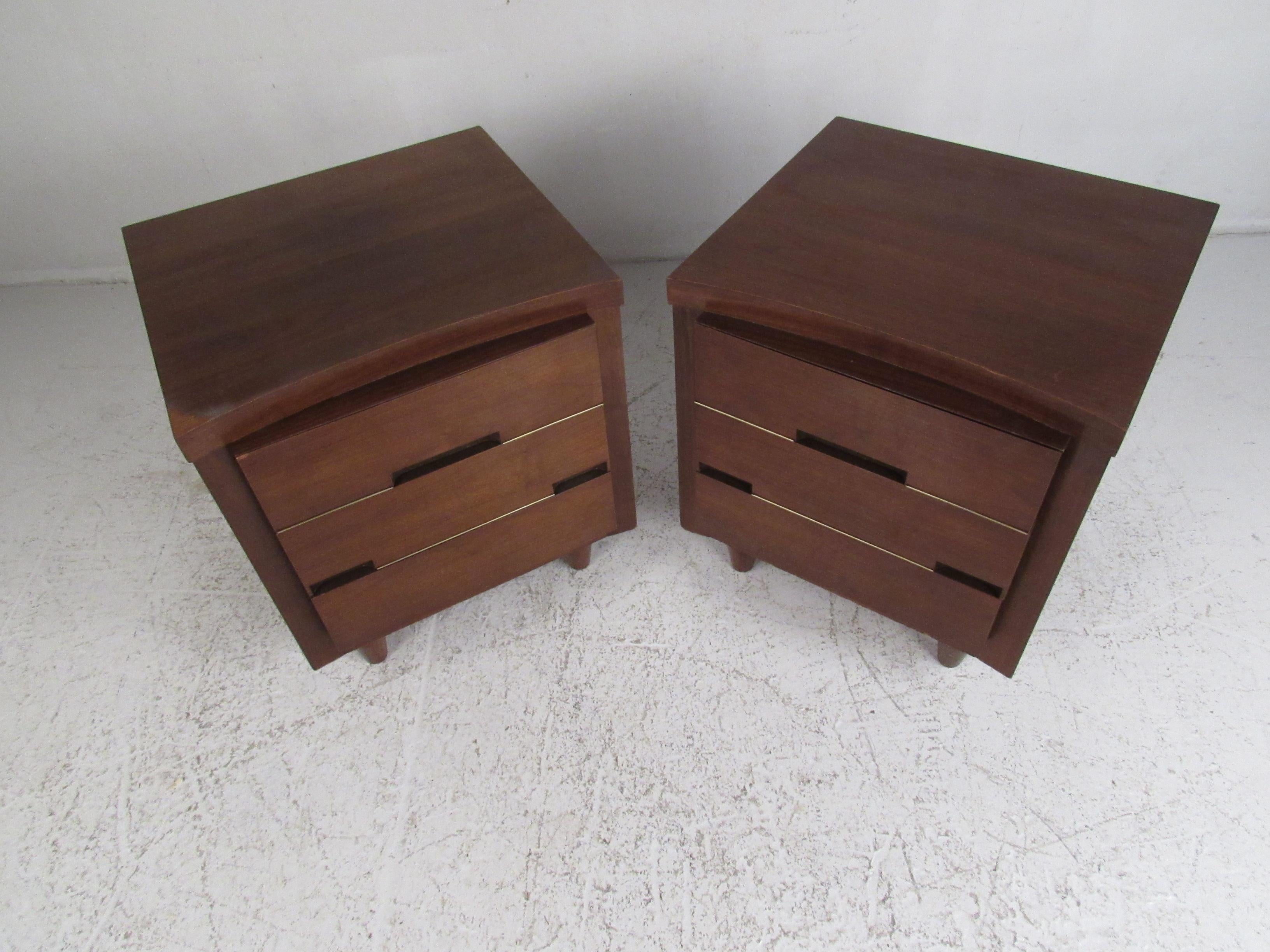 This stunning pair of vintage modern end tables boast unusual drawer fronts with recessed pulls. Quality construction with curved front tops, stubby tapered legs, and a vintage walnut finish. This charming pair of nightstands make the perfect