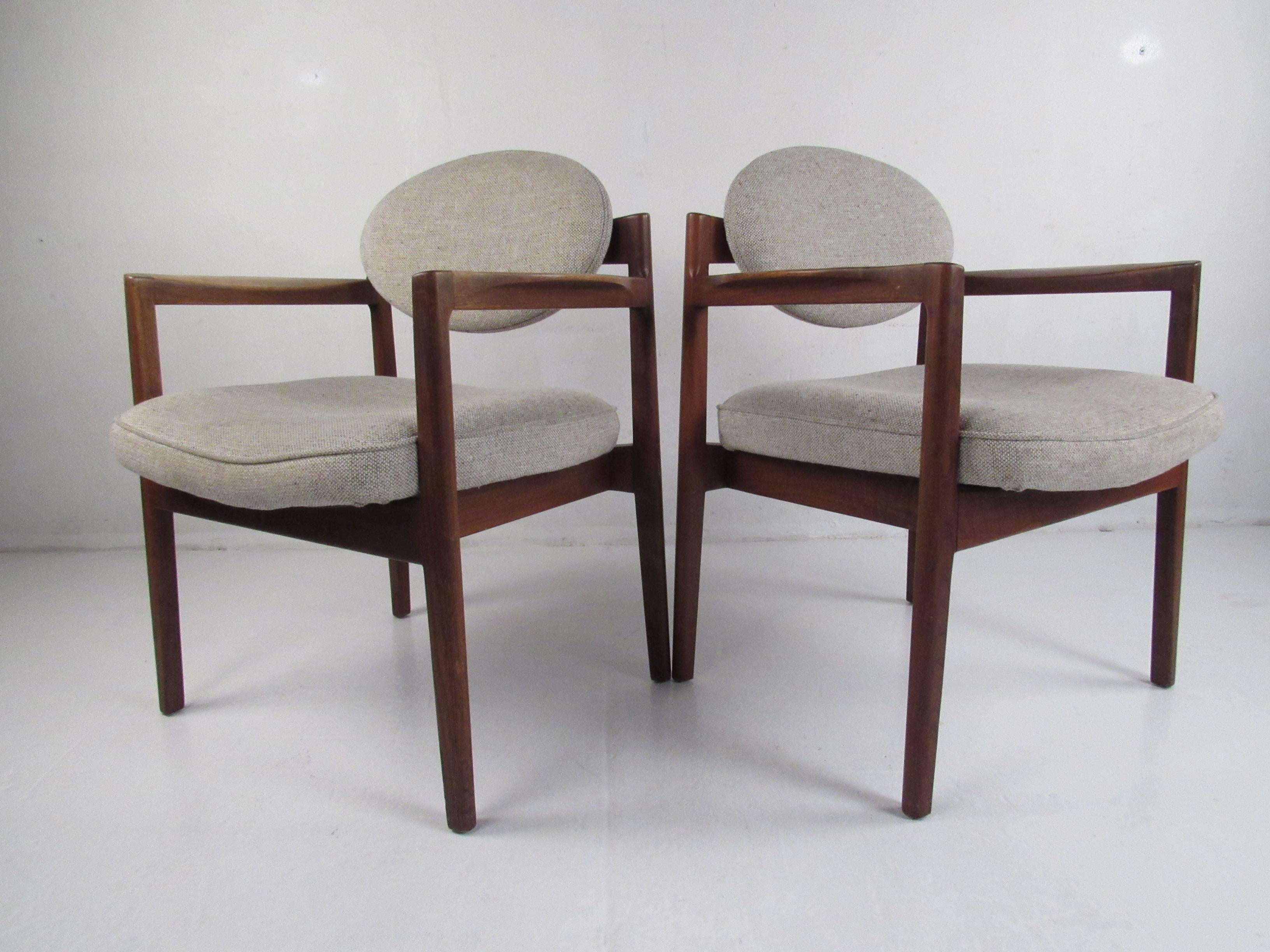 This beautiful pair of vintage Jens Risom chairs boast sculpted arm rests, tapered legs, and soft light gray upholstery. An extremely unique design with floating circular back rests and thick padded seating. Quality craftsmanship with straight lines