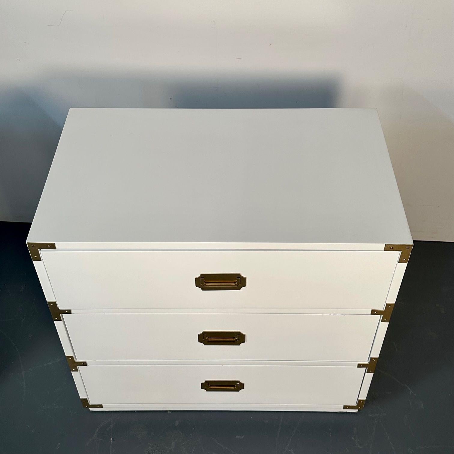 Pair of Mid-Century Modern White Campaign Dressers / Nightstands, Brass Accent
 
Set of two newly refinished white nightstands/dressers. Having a high gloss white lacquer finish with original brass hardware. Matching dresser available separately.