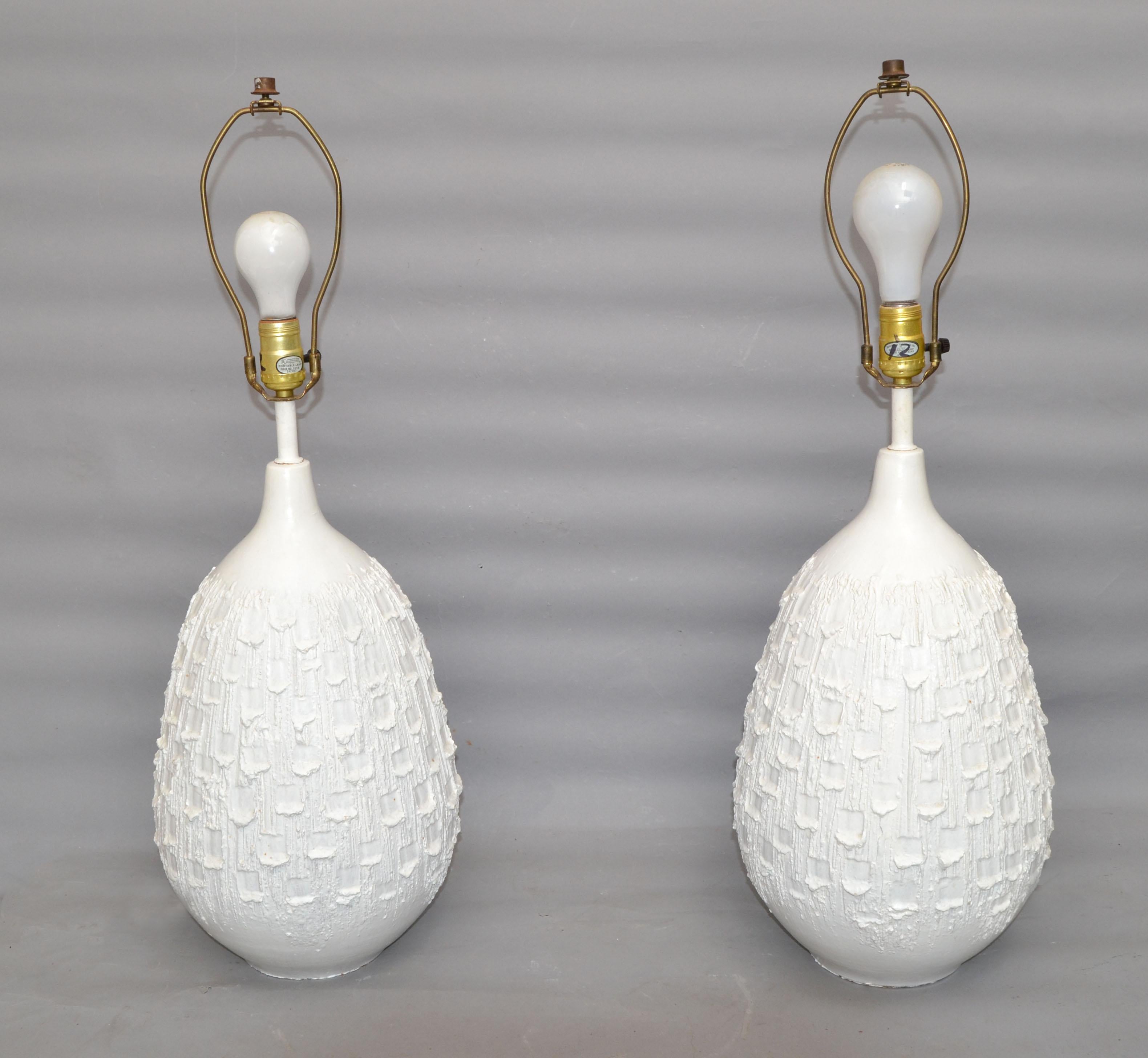 Paire de lampes de table en céramique blanche de style Mid-Century Modern à la texture rugueuse. 
Câblée pour les États-Unis, chaque lampe peut être alimentée par une ampoule ordinaire ou LED.
L'abat-jour n'est pas inclus.
Hauteur au sommet de la