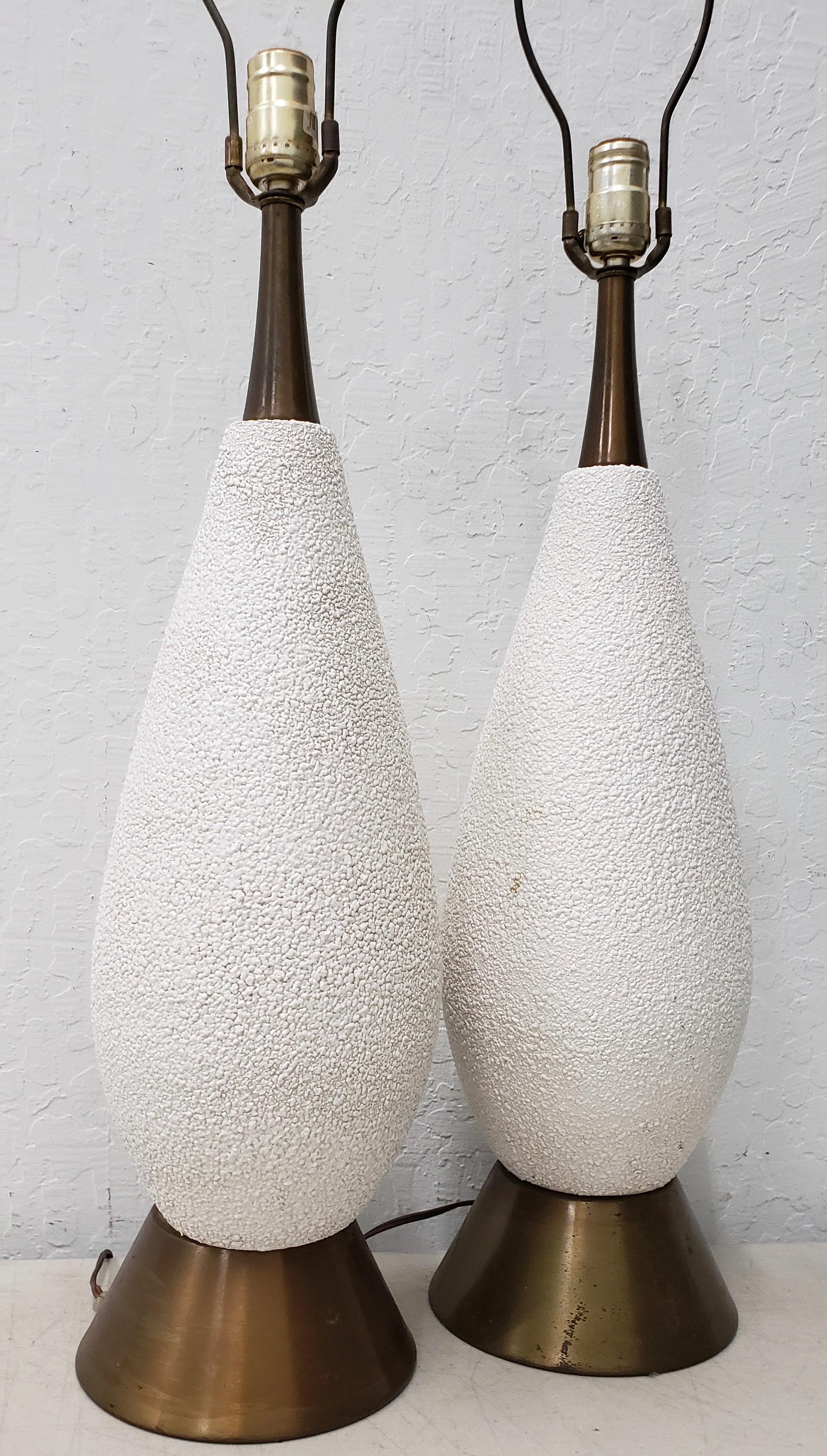 Pair of Mid-Century Modern white textured ceramic table lamps, circa 1950

White textured ceramics. Vintage lamps wired and ready to illuminate.

Each lamp measures 7