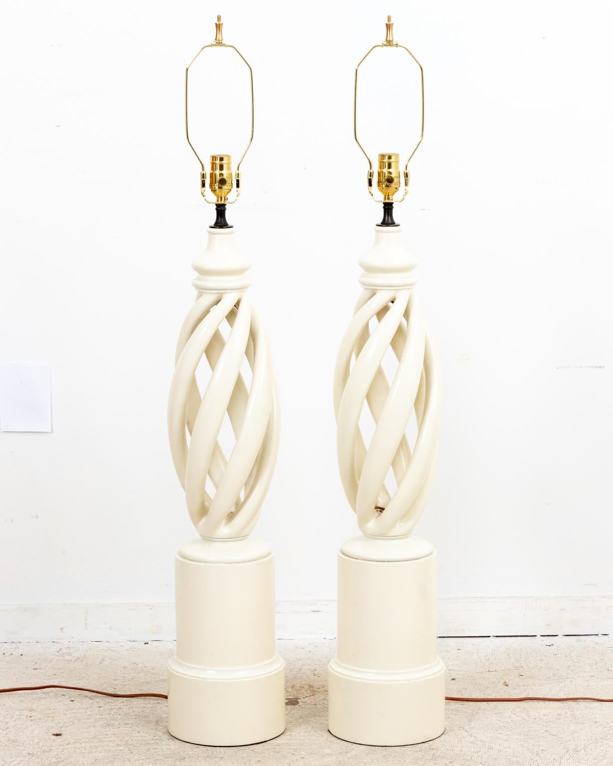 Circa mid-20th century pair of Mid-Century Modern style white painted wood swirl lamps in the manner of James Mont on rounded bases. Made in the United States. Please note of wear consistent with age. Shades not included.