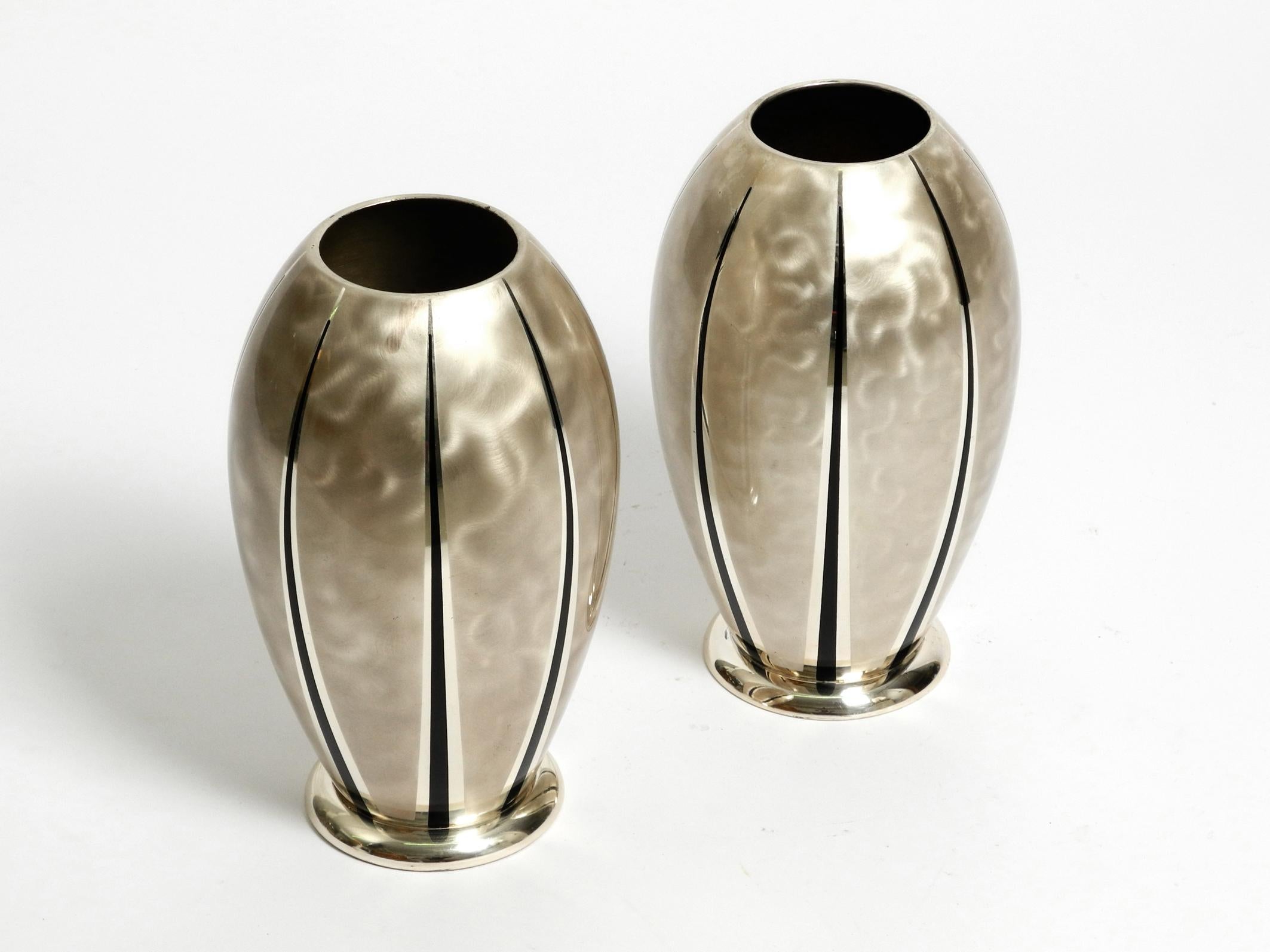 Paire de grands vases de table en laiton argenté de WMF Ikora. Fabriqué dans les années 1950. Fabriqué en Allemagne.
Magnifique design du milieu du siècle. L'argent est poli mat avec des bandes noires.
Les deux vases sont de forme et de taille