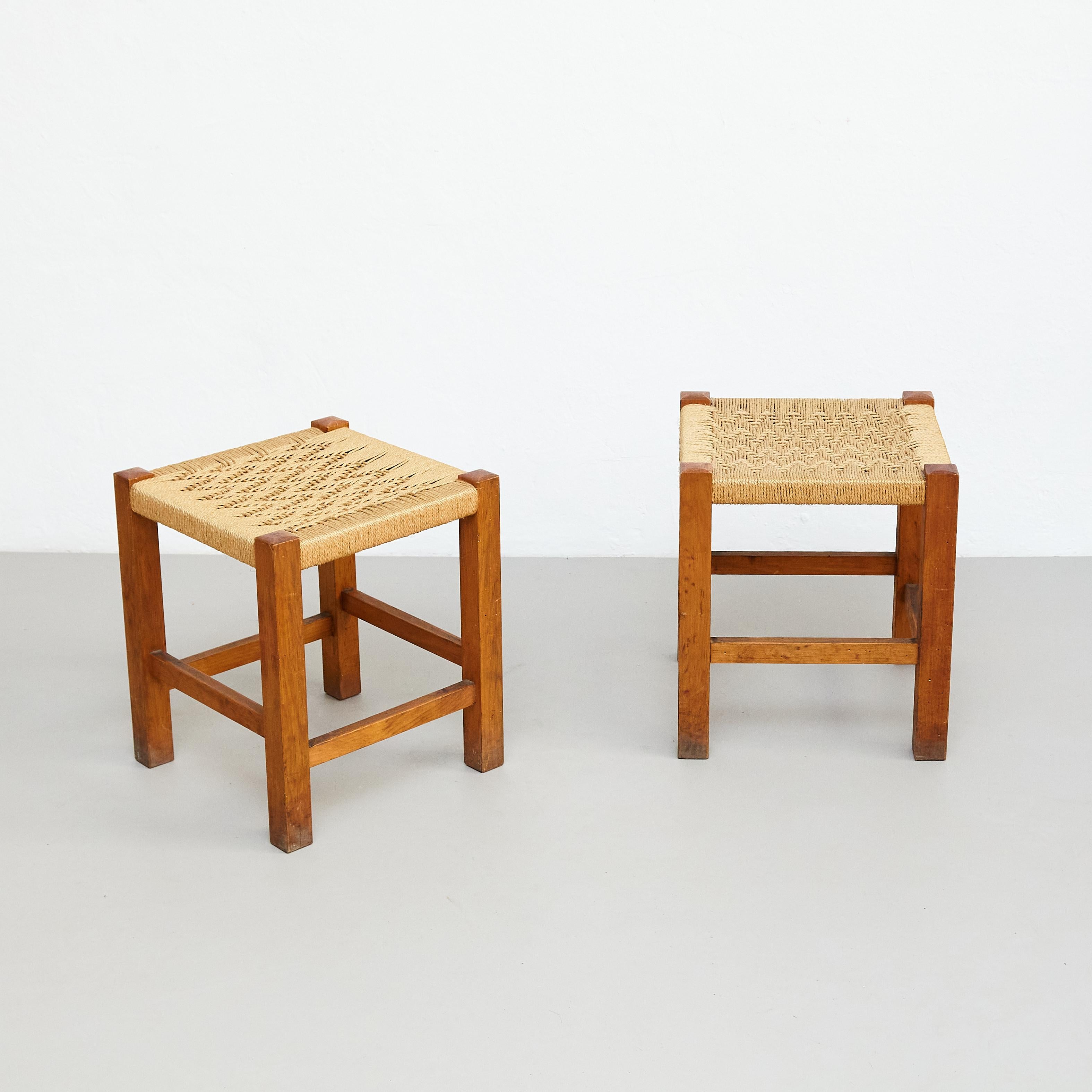 Pair of Mid-Century Modern wood and Rattan French stools, circa 1960, by unknown designer.

Manufactured in France, circa 1960.

In original condition with minor wear consistent of age and use, preserving a beautiful patina.

Materials: