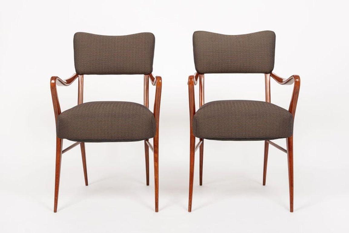 This beautiful pair of vintage mid century modern arm chairs attributed to mid century Italian designer Gio Ponti are circa 1950. The distinctive design features sculptural, lacquered solid wood frames with clean, elegant lines and gentle, organic