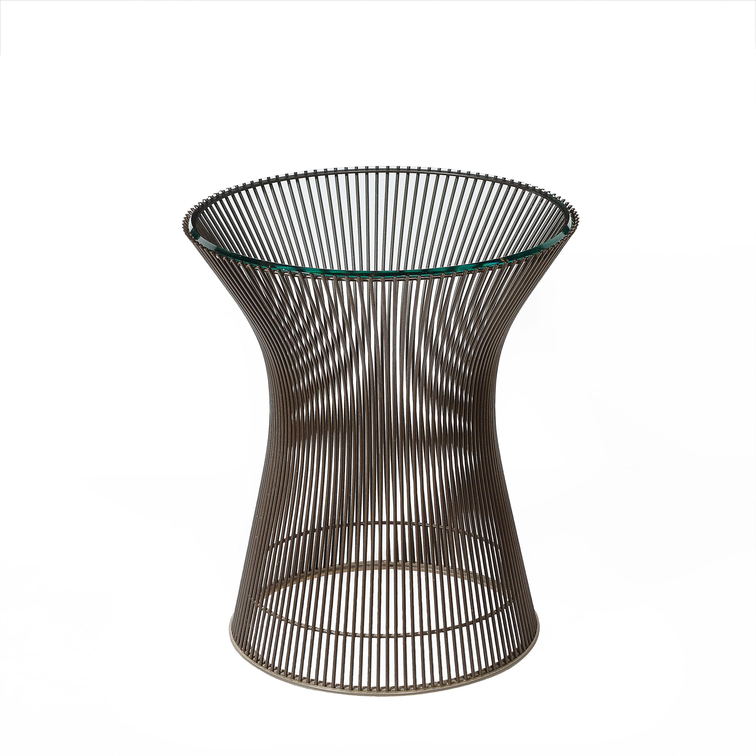 This reserved and thoughtfully achieved Pair of Mid-Century Modernist Bronze Side Tables by Warren Platner originates from the United States, Circa 1960. They feature a contoured body composed of numerous parallel bronze rods, moving up and slightly