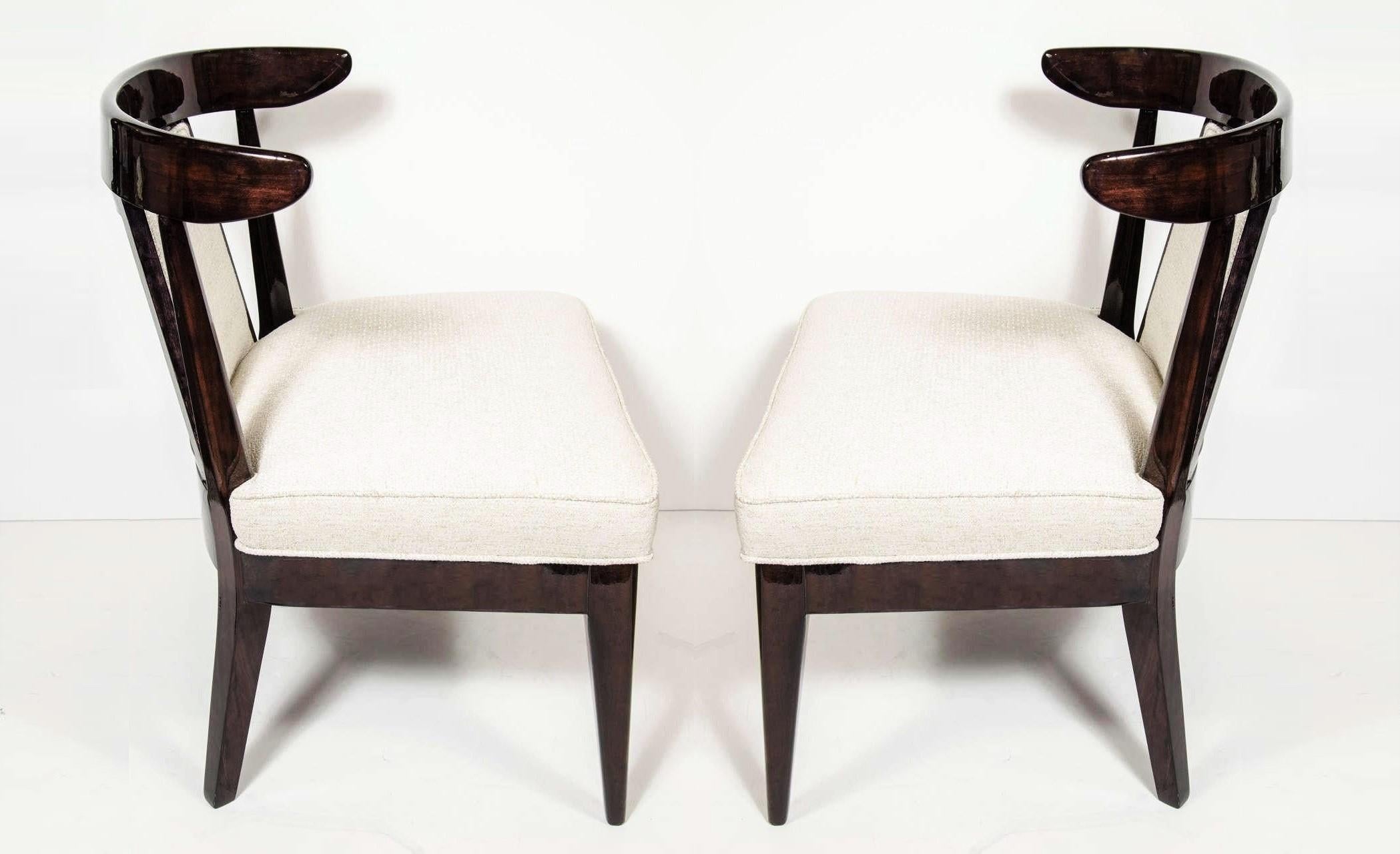 These very sophisticated pair of low profile chairs are a perfect blend of Hollywood Glam and Mid-Century Modern design. Featuring ebonized walnut klismos form frames with upholstered splat backs and seats that rise above tapered legs. Beautifully
