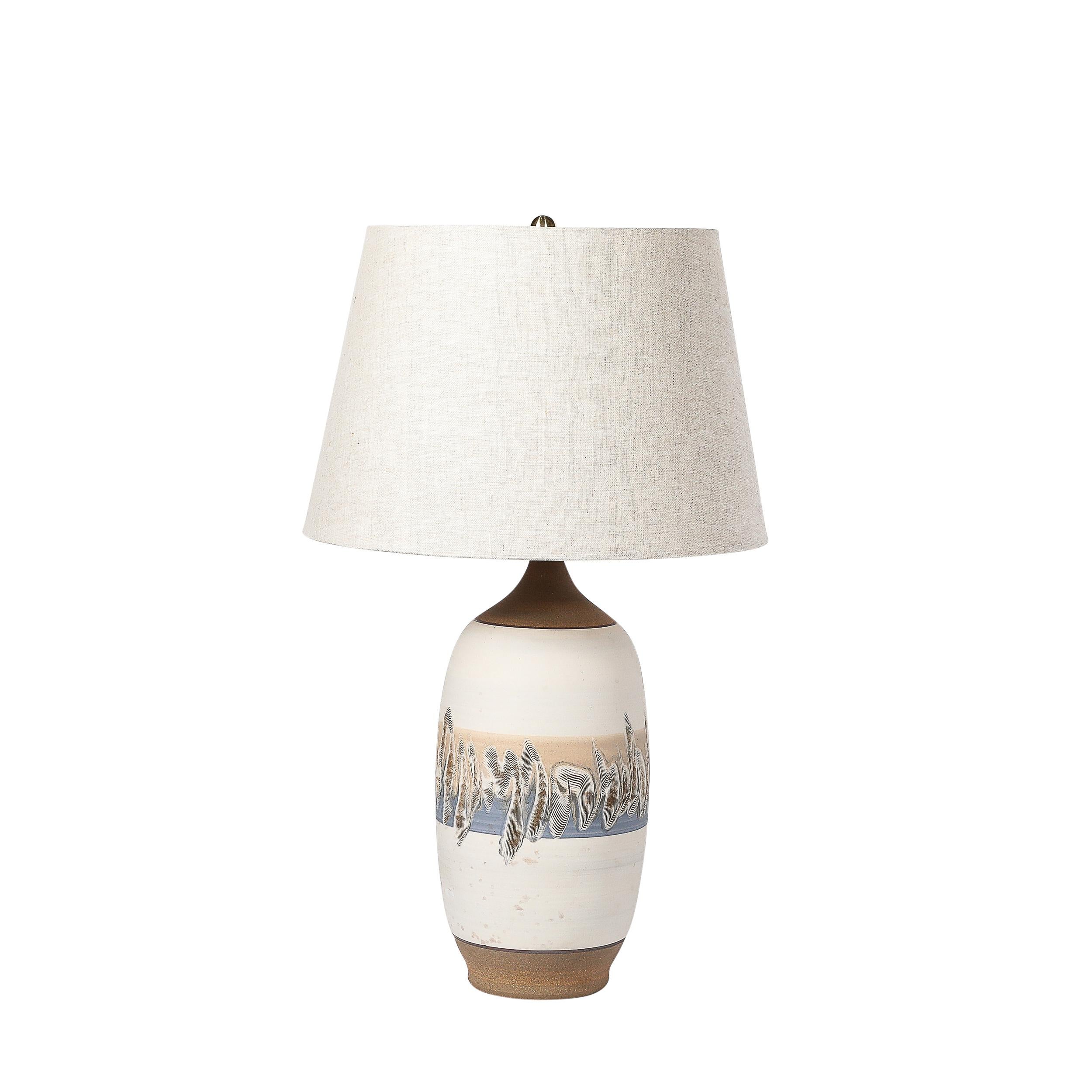 Cette paire de lampes de table en céramique blanc cassé de style moderniste du milieu du siècle, aux textures artisanales exquises, est originaire des États-Unis, vers 1970. Elles présentent des corps arrondis en forme d'urne avec de la céramique