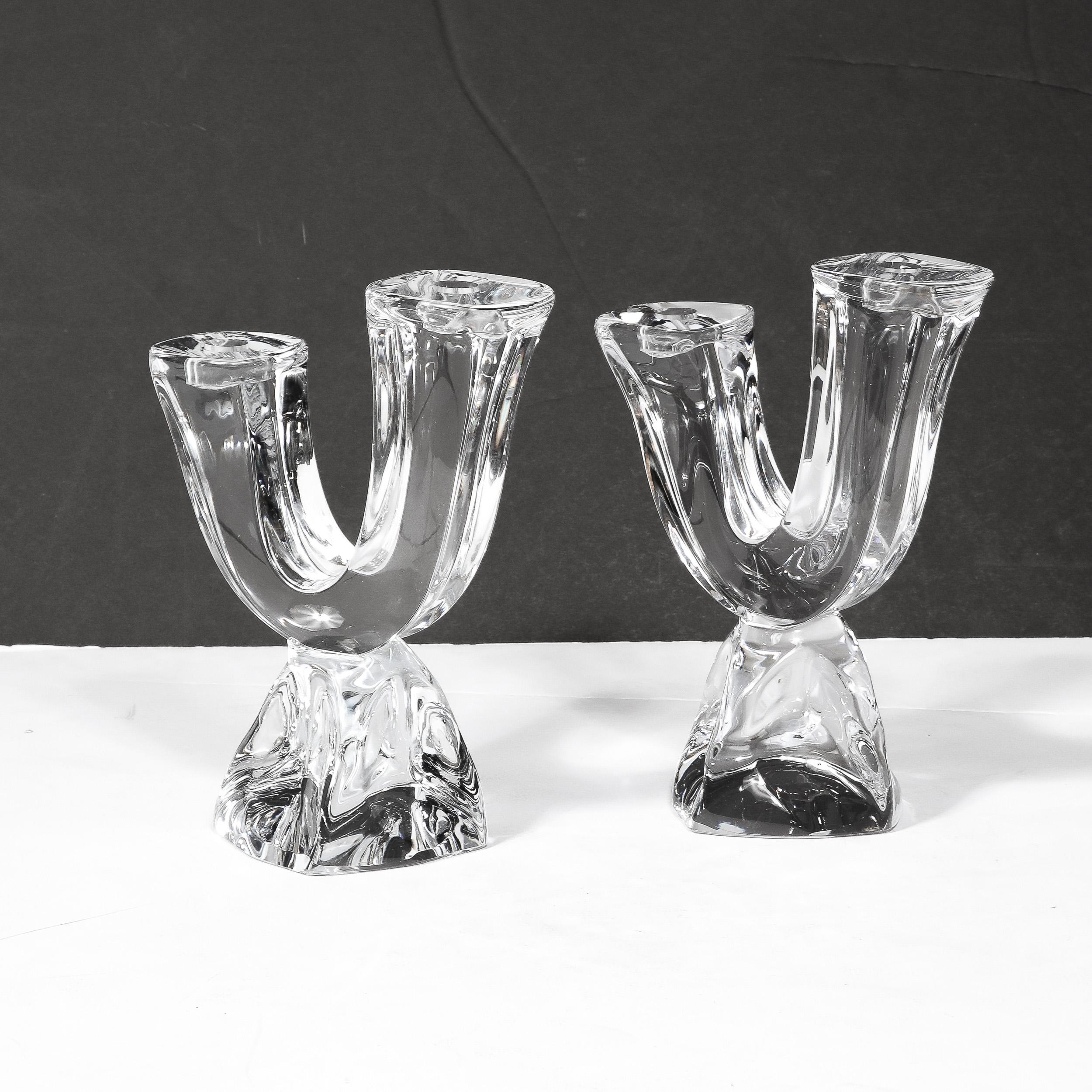 Questa audace e sontuosa coppia di portacandele di cristallo modernista della metà del secolo è stata realizzata dalla stimata azienda di vetro artistico Daum a Nancy, in Francia, intorno al 1960. Il cristallo emana un raro grado di elegante
