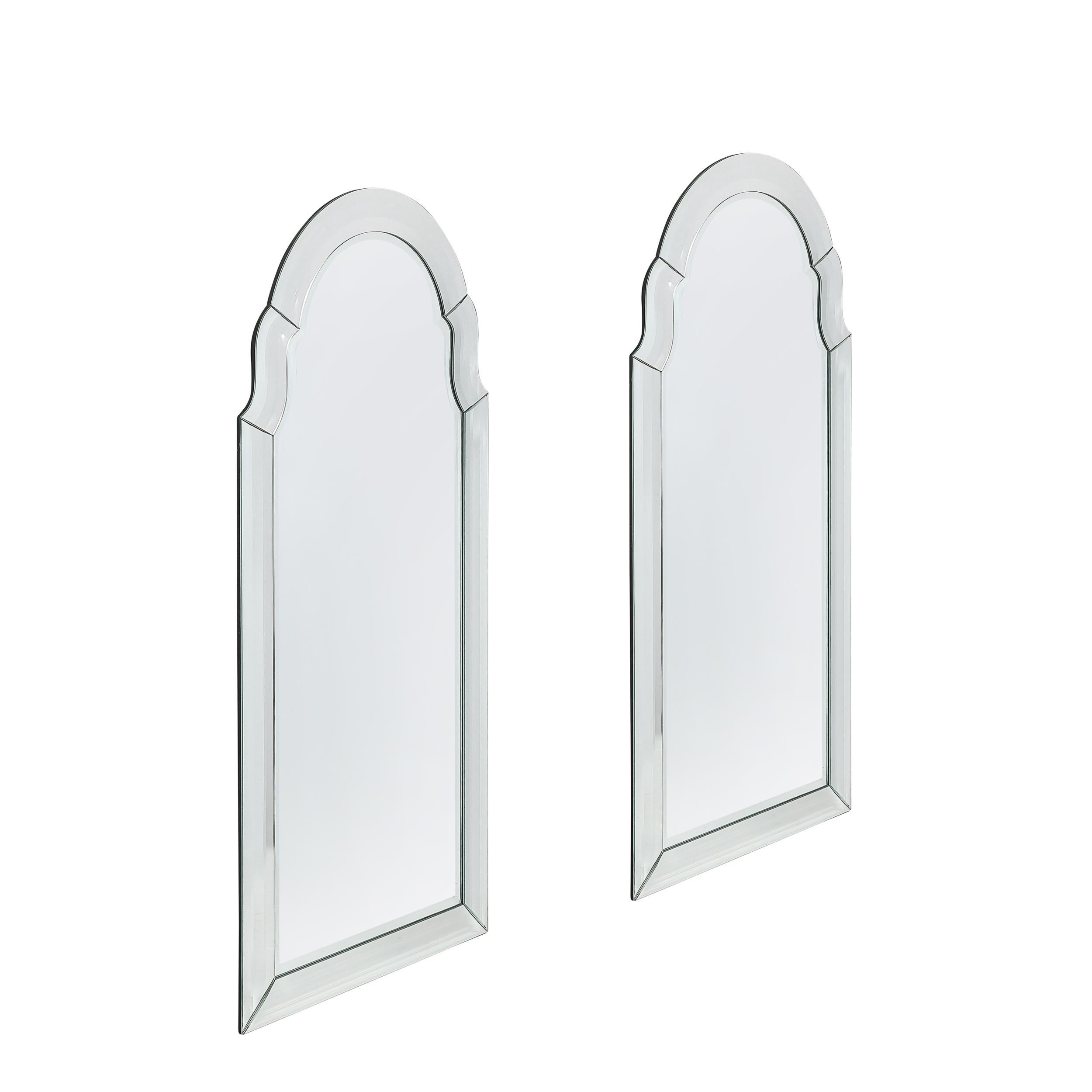 Cette paire distinguée de miroirs en forme d'arche avec empattement, fabriqués aux États-Unis vers 1960, incarne les principes de conception épurés et sculpturaux caractéristiques de l'époque. Avec leur forme élégante et leurs courbes classiques,