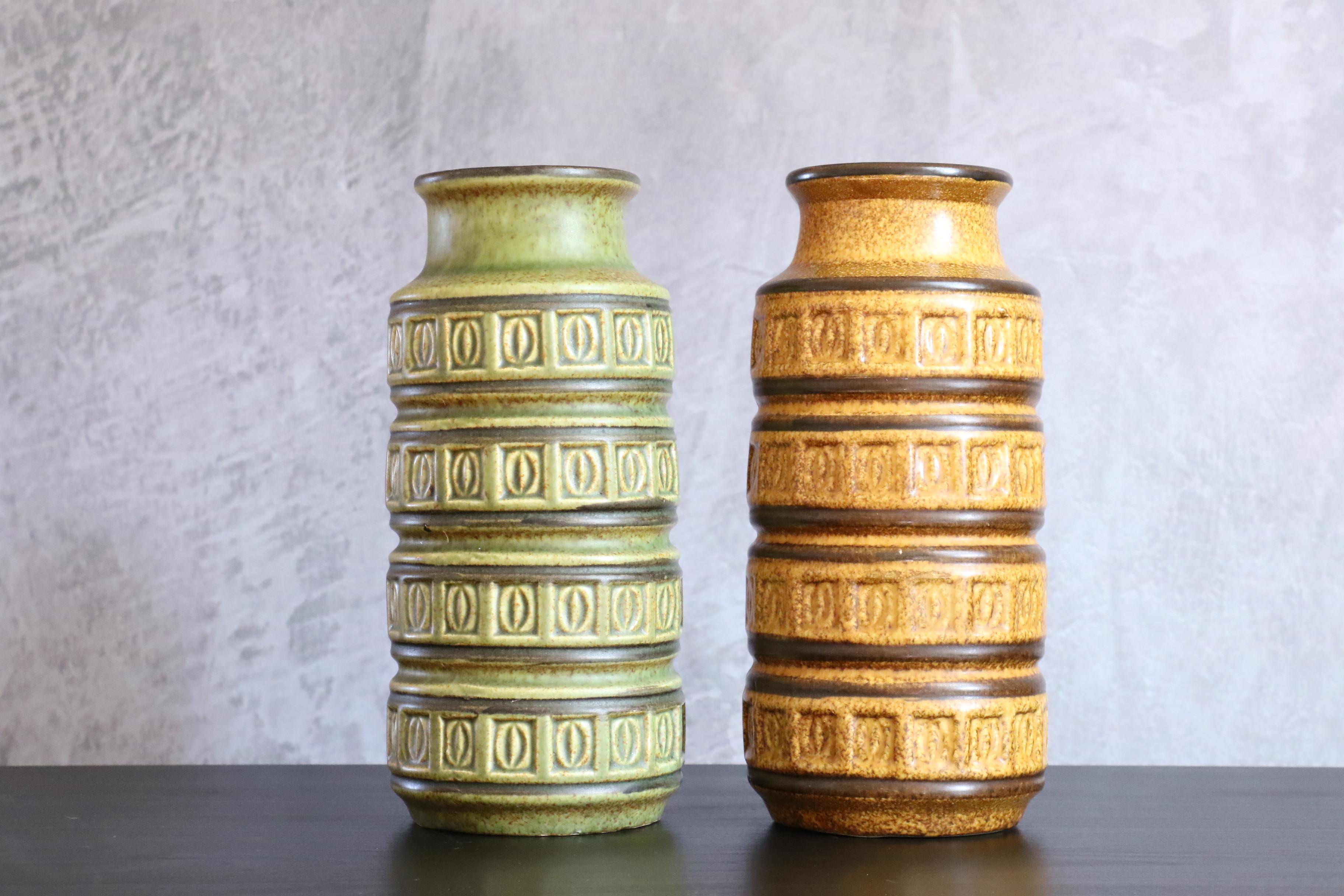 Pair of Mid-Century Modernist West German vases by Scheurich Keramik, circa 1970

Beautiful and silky green and amber color with embossed relief pattern or motif. Classic 1970s Western Germany design.

On the last two pictures you can see other