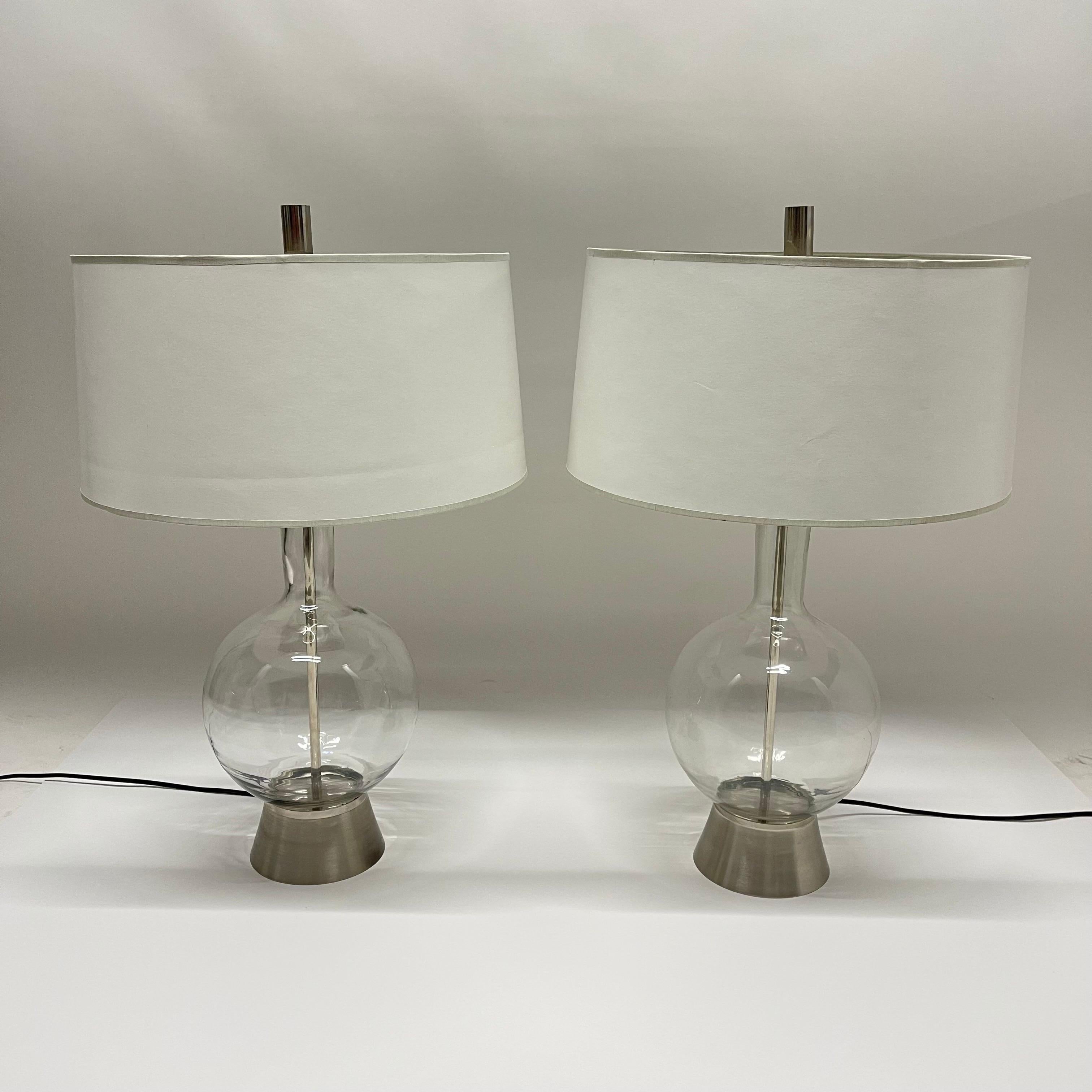 Pair of exquisite mid-century blown glass table lamps, rendered in clear mouth blown glass with brushed nickel bases and nickel sockets, harps, and finials.

Dimensions:
10