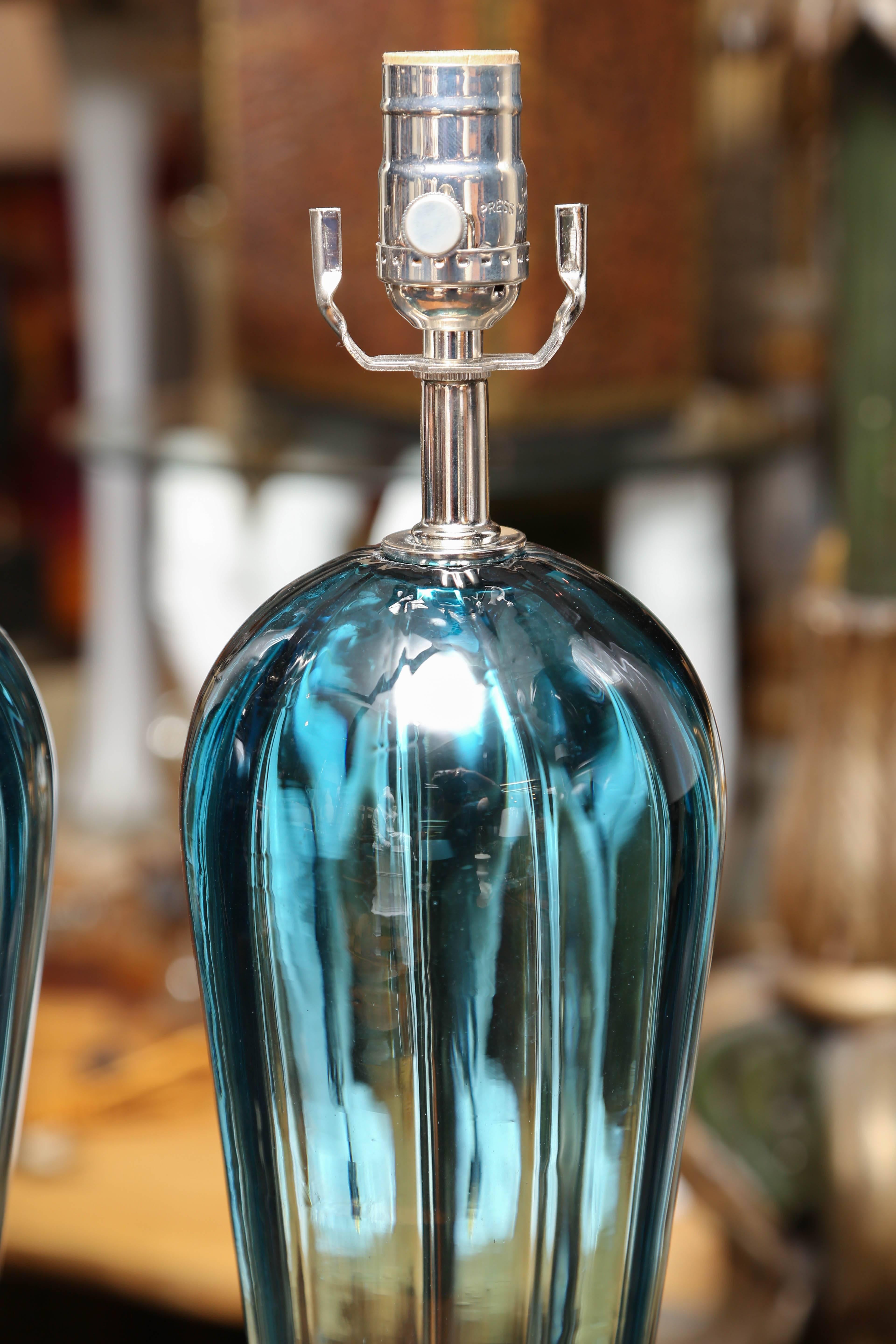 An elegant and stately pair with long tapered bodies and outstanding teal blue color.
The lamps are raised upon stepped-up lucite bases.