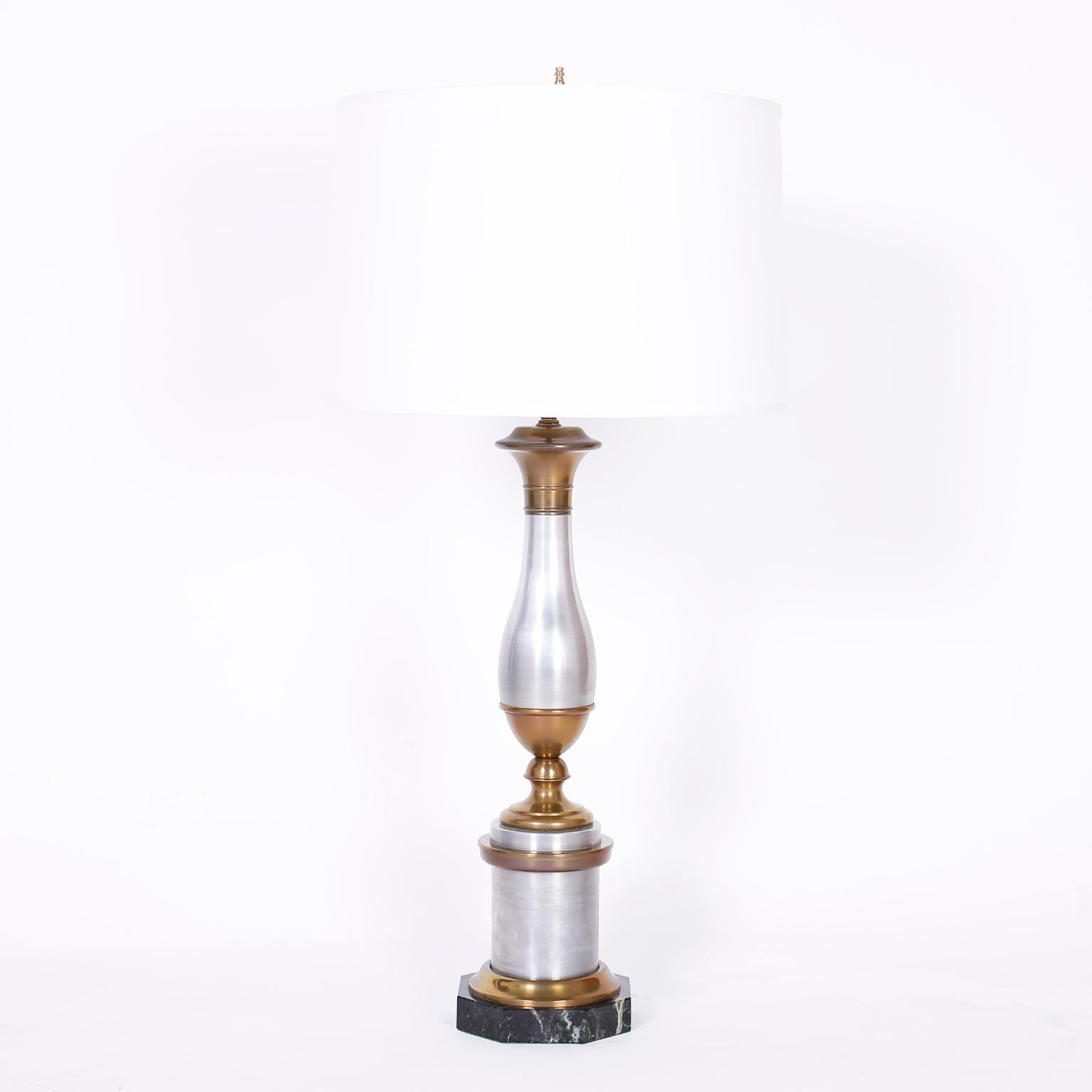 Impressive pair of neoclassic style table lamps crafted in brass and brushed aluminum on an octagon black marble base.