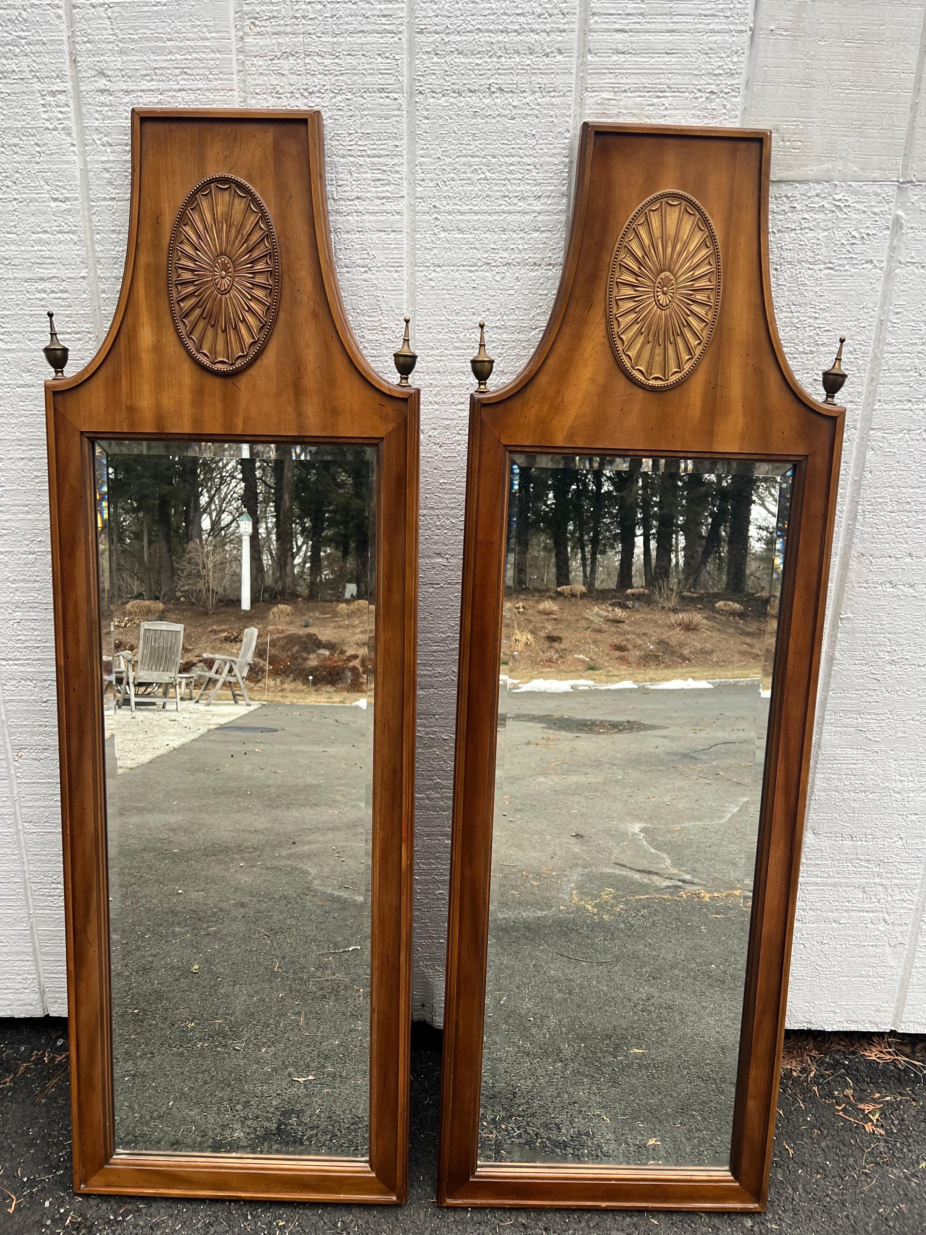 Coppia di specchi in stile neoclassico della metà del secolo scorso. Bellissimi specchi smussati con terminali decorativi e un medaglione ovale in alto al centro. Tono del legno di mogano. Perfetto per un bagno padronale sopra i lavandini o in un