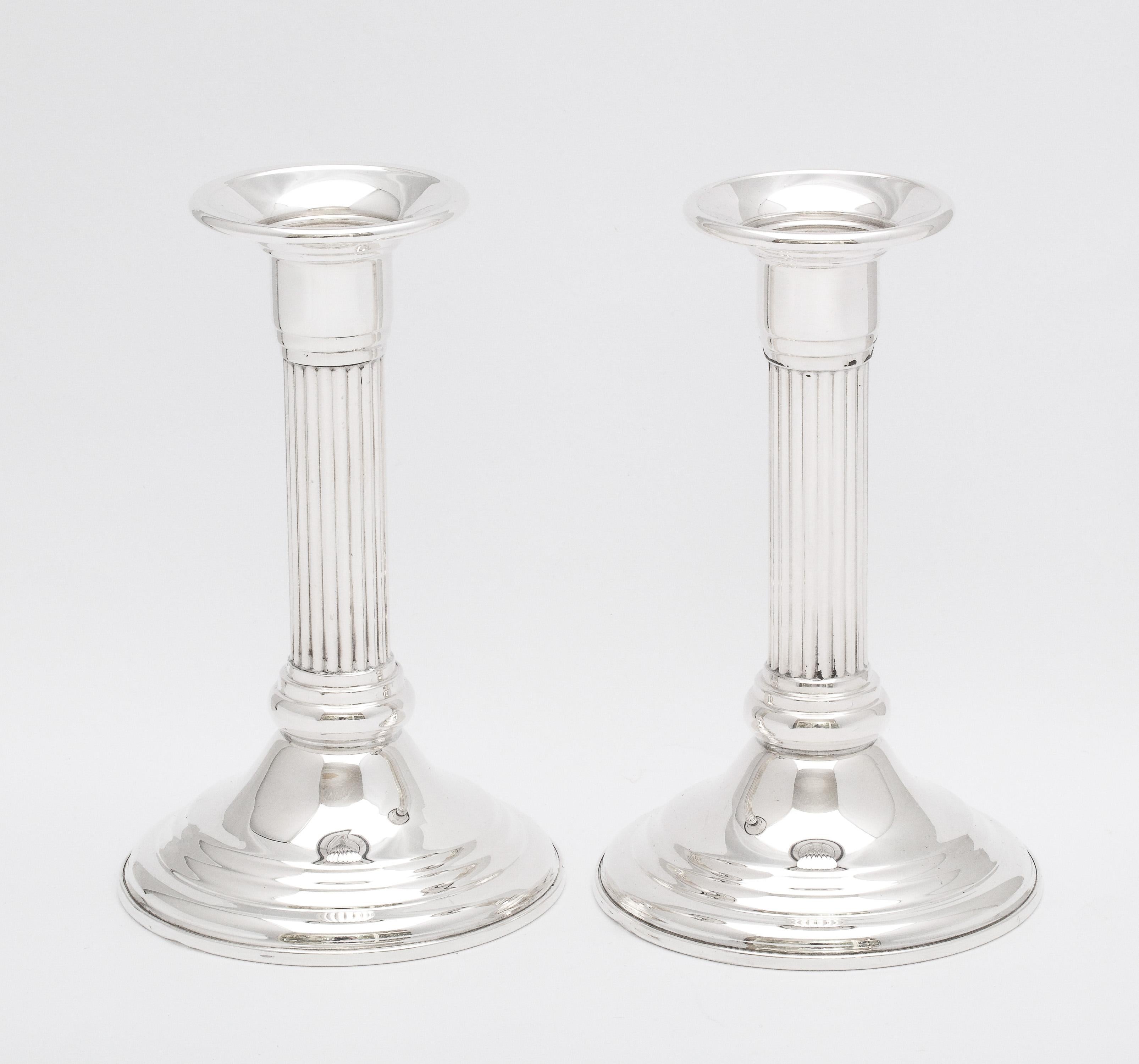 Pair of mid-century, sterling silver, Neoclassical-style, column-form candlesticks, Empire Silver Co., New York, Ca. 1960's. Each measures 5 3/4 inches tall x 3 1/2 inches diameter across base. Columns are fluted in design. Weighted. Dark areas in