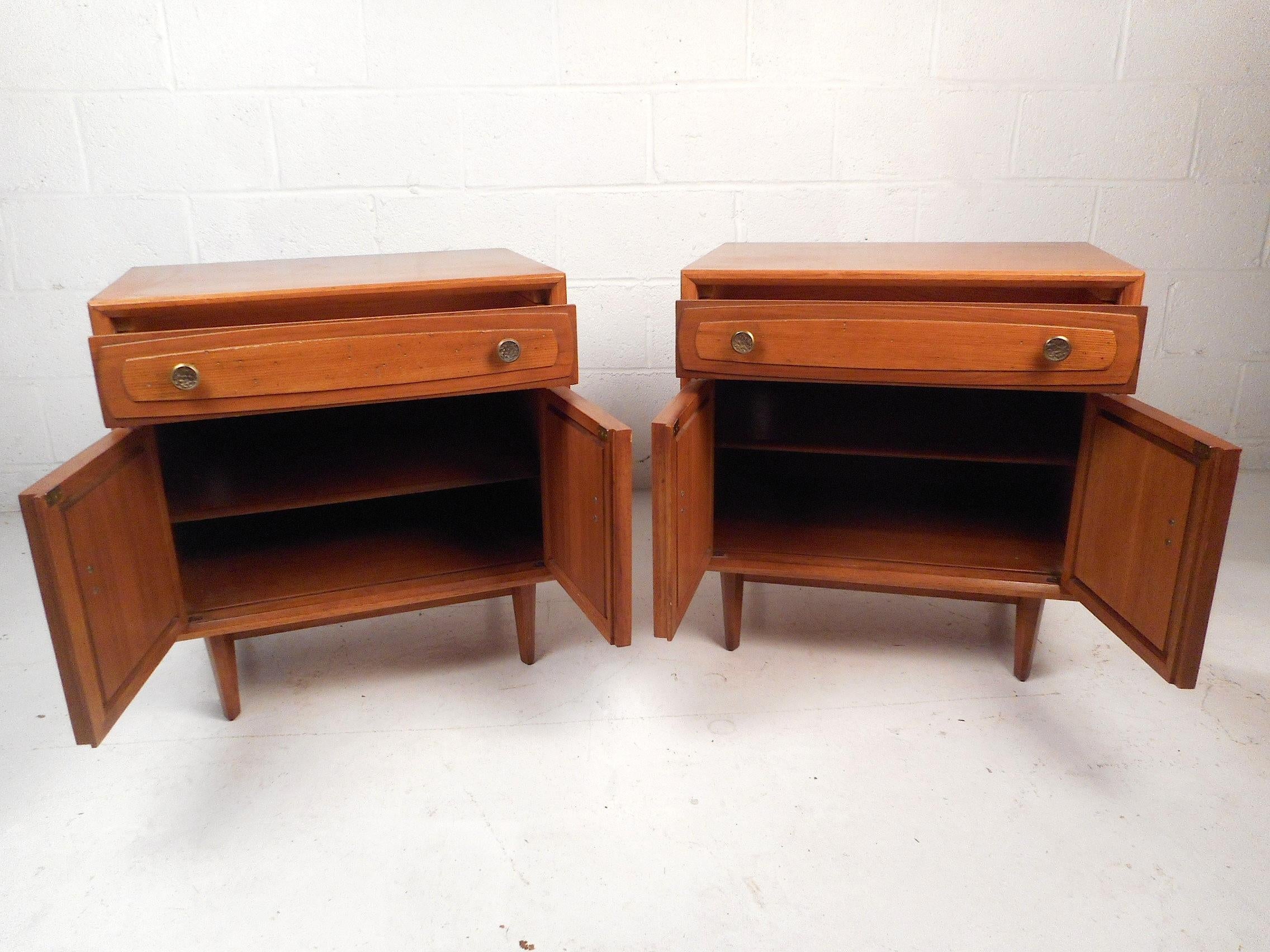 This stylish pair of midcentury nightstands feature a sturdy walnut construction with an elegant vintage finish, adjustable interior shelves offering plentiful and dynamic storage space, interestingly textured drawer pulls, and dovetail-jointed