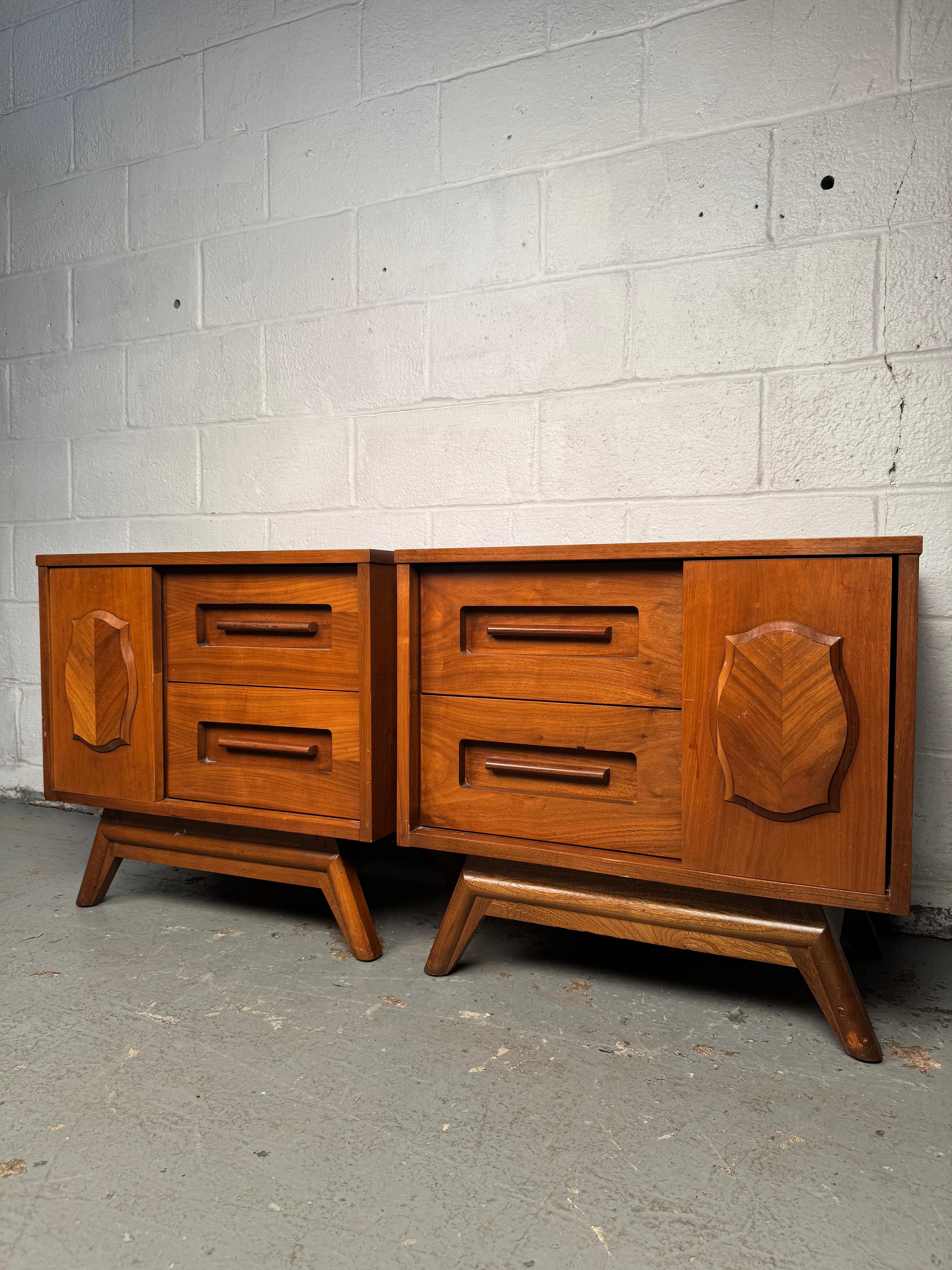 Elegant pair of mid-century nightstands by Young Manufacturing, crafted in warm walnut with clean modern lines. Each table offers practical storage with drawers and open shelving, combining functionality with refined design. A versatile and timeless