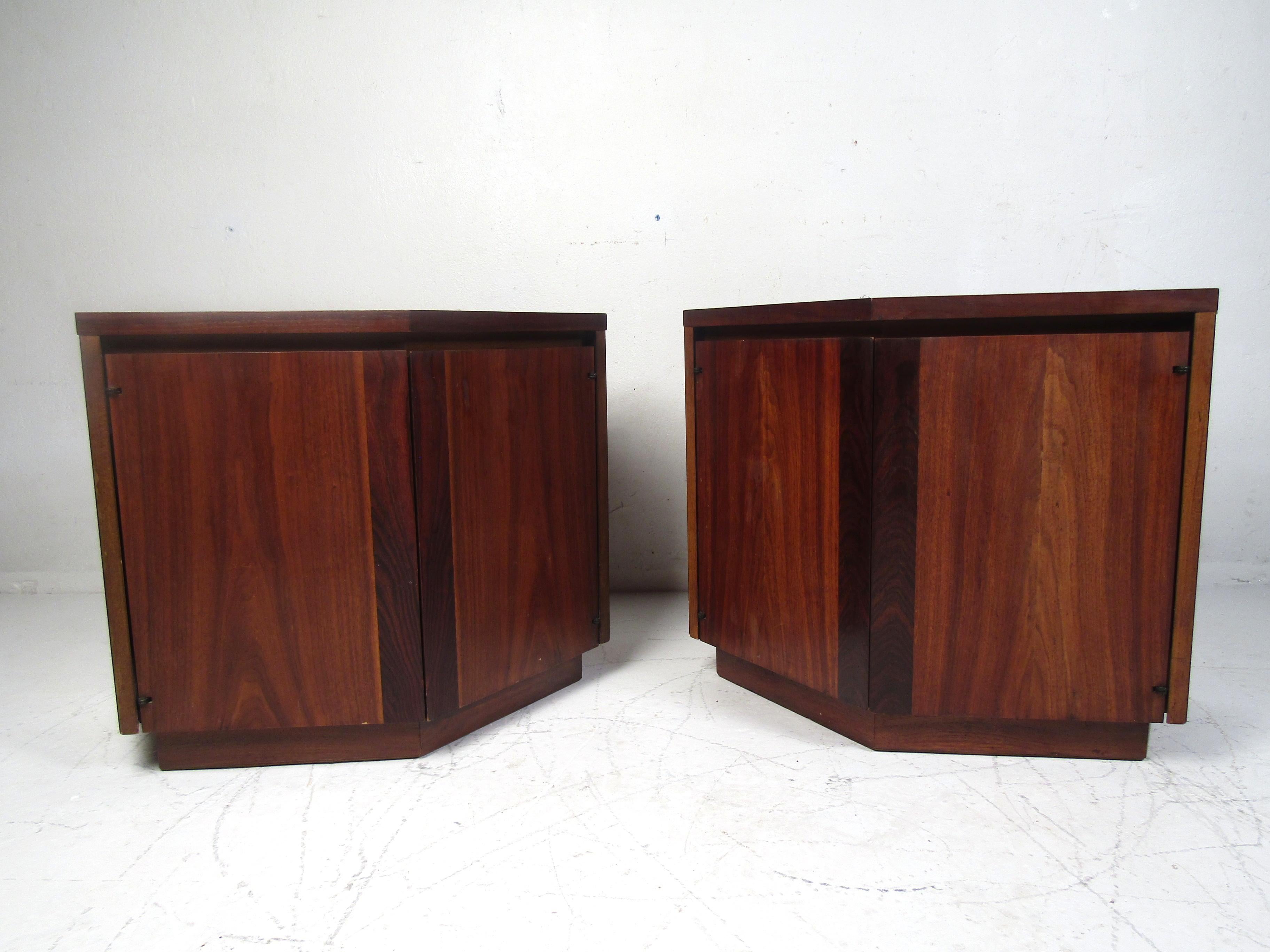 Beautiful pair of midcentury nightstands with a combination of walnut and rosewood veneers covering the case. Unusual construction with an angled front-end. This pair is sure to prove a nice addition to any modern interior. Please confirm item