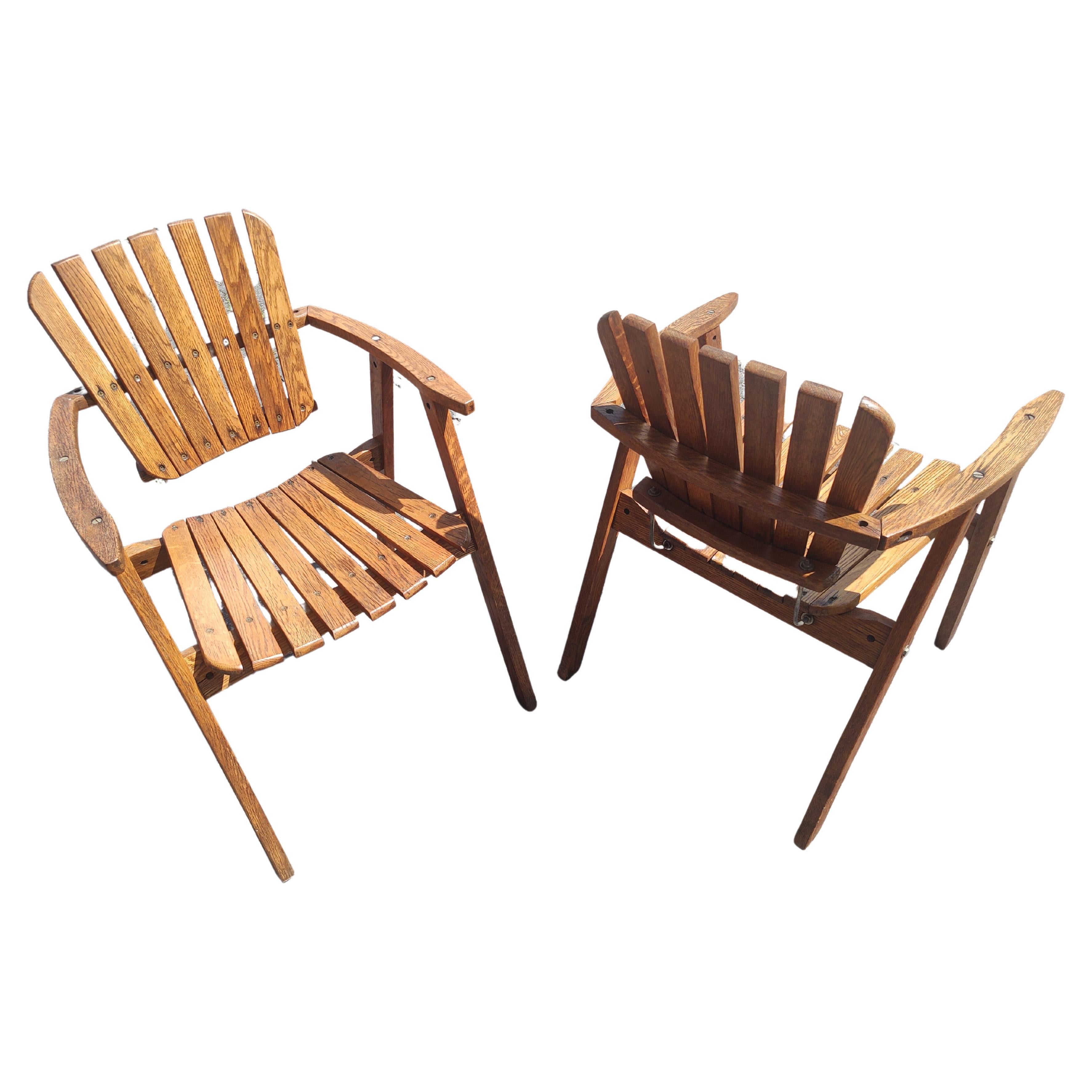 Fabuleuse paire de fauteuils sculpturaux en chêne du milieu du siècle dernier convenant à un porche fermé ou couvert. Assise et dossier en chêne massif à lattes avec un système de support en fer pour le dossier. Style de Carlo Hauner & Martin