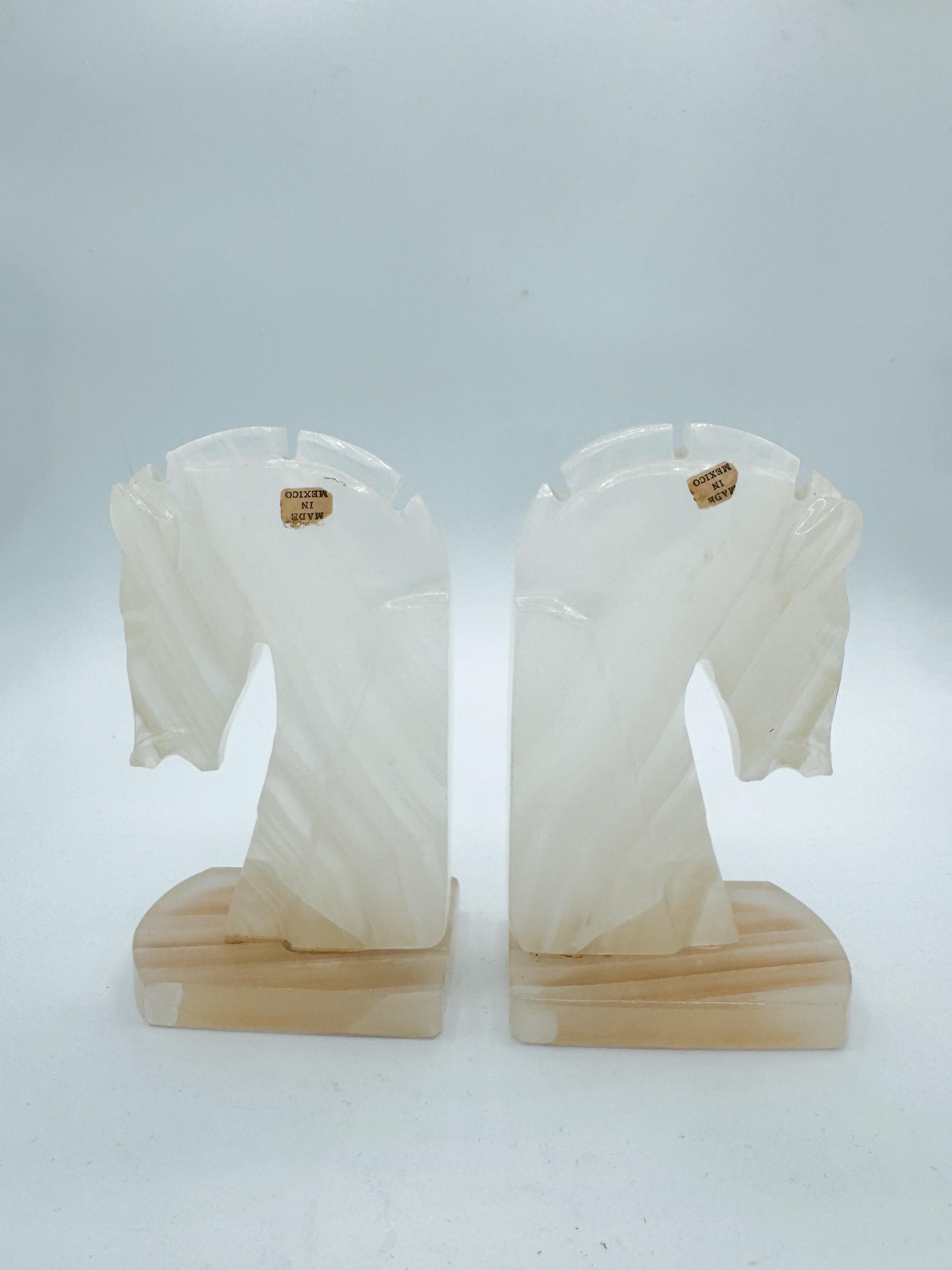 Impressionante e scultorea, questa coppia di grandi reggilibri a testa di cavallo in marmo del Mid-Century emana un'eleganza e una maestria senza tempo. Realizzato in Messico intorno agli anni '70, ogni pezzo è sapientemente scolpito in onice