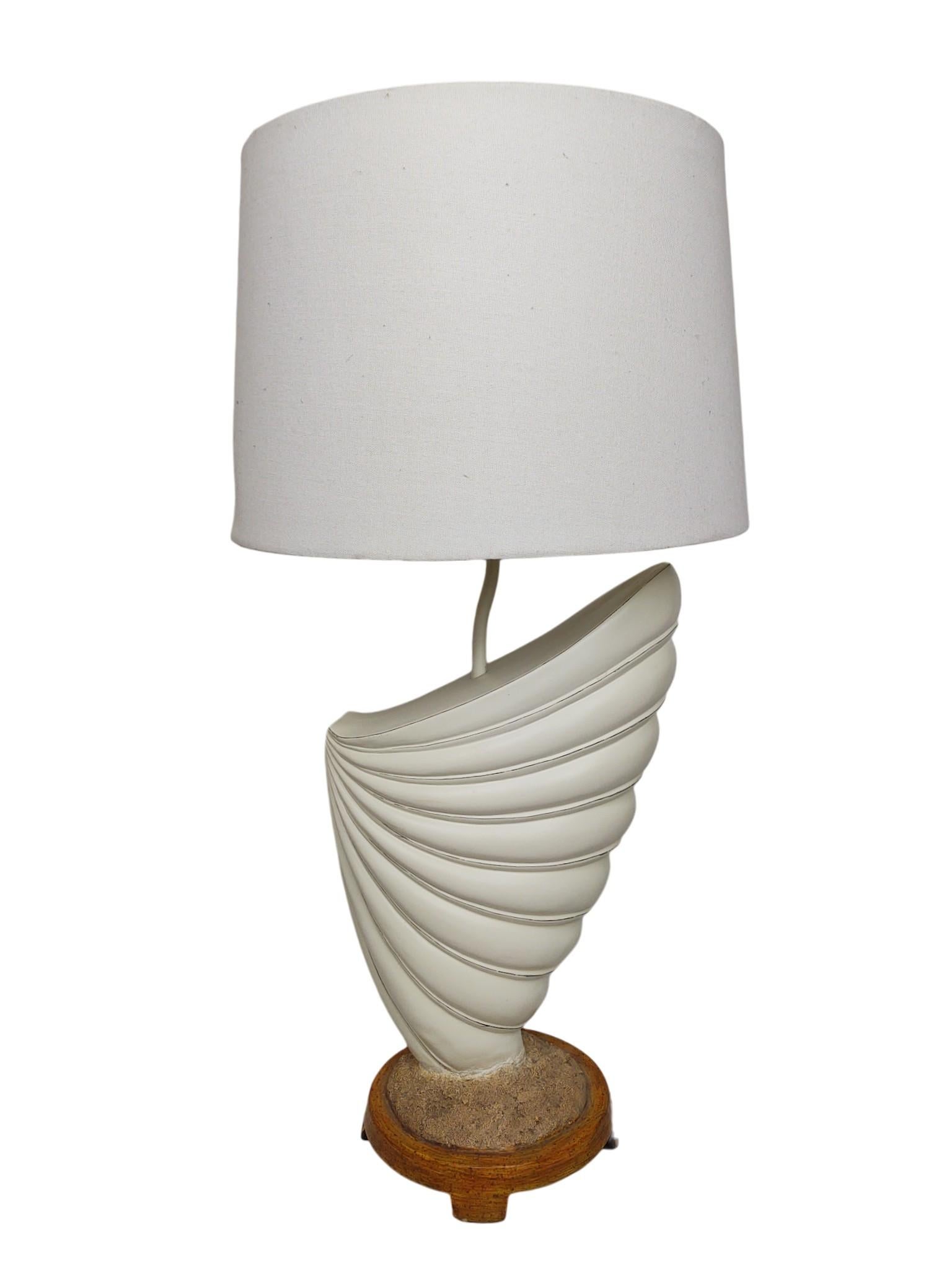 This stylish pair of vintage table lamps perfectly captures the relaxed style of Coastal, Palm Beach, and Tropical Regency design. Sculptural, each lamp features a large, spiraled seashell form—reminiscent of a conch or chambered nautilus—crafted