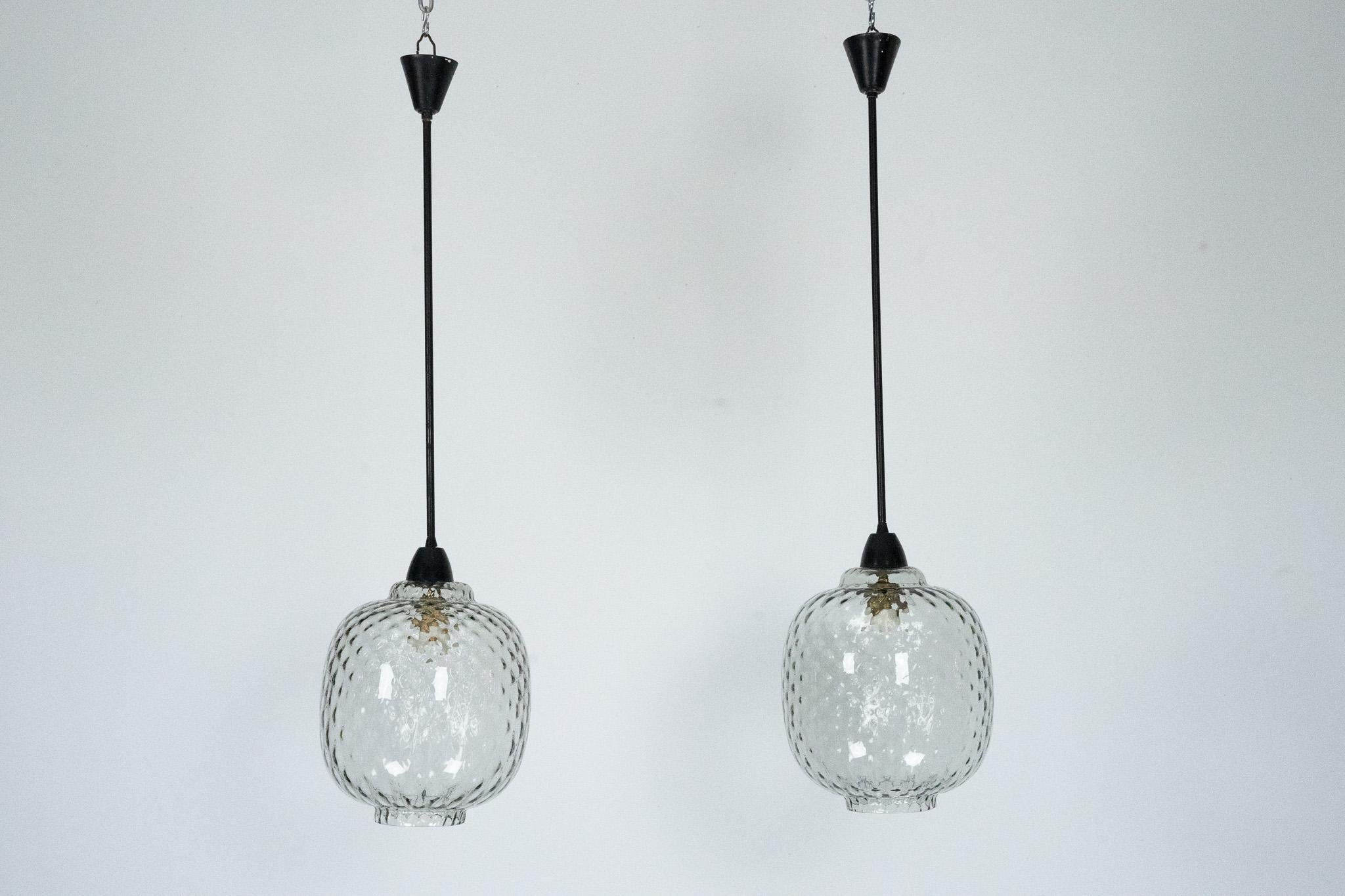 Ogni lampada presenta un paralume in vetro soffiato a mano con una superficie delicatamente ondulata e una morbida finitura fumé. La raffinata lavorazione artigianale e la forma organica esemplificano l'eleganza senza tempo del design italiano di