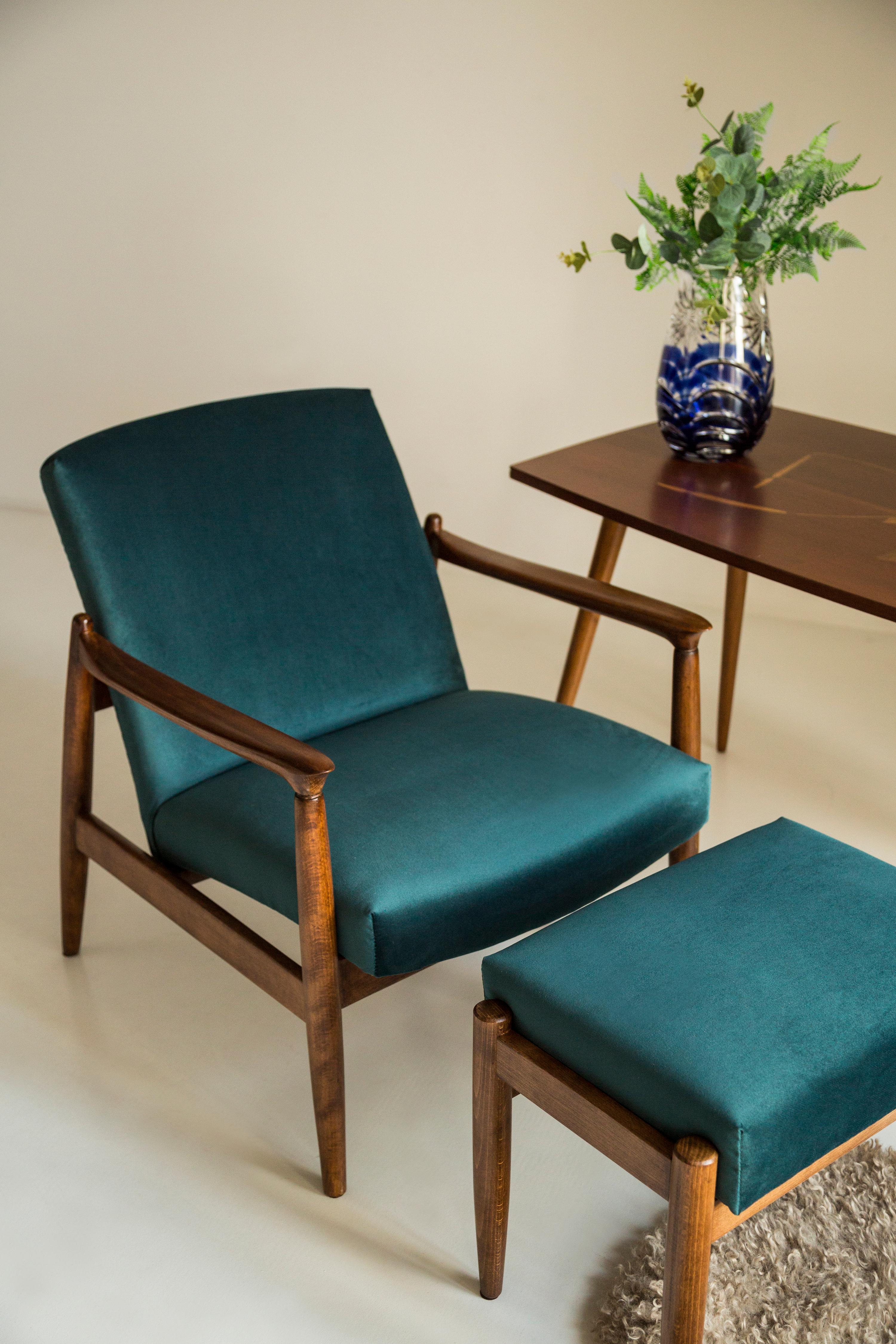 A pair of petrol blue armchairs, designed by Edmund Homa. The armchairs were made in the 1960s in the Gosciecinska Furniture Factory. They are made from solid beechwood. The GFM type armchair is regarded one of the best Polish armchair design from