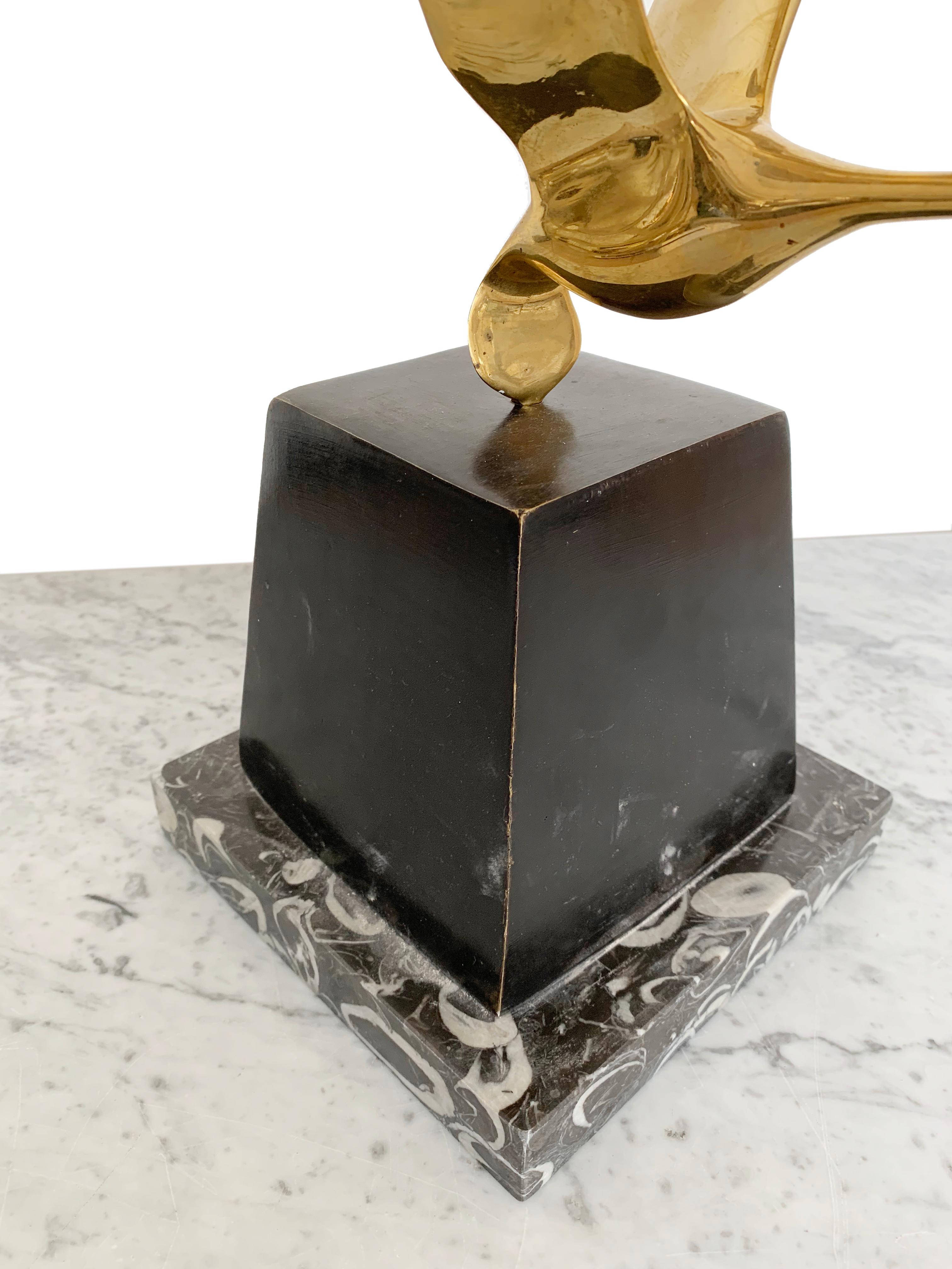 Elegant Mid-Century Modern polished brass sculptures in the form of flying wild birds.
Heavy geometric bronze body with original brown patina finishing on a polished marble base. The brass flying birds fit neatly into the bronze base.
The