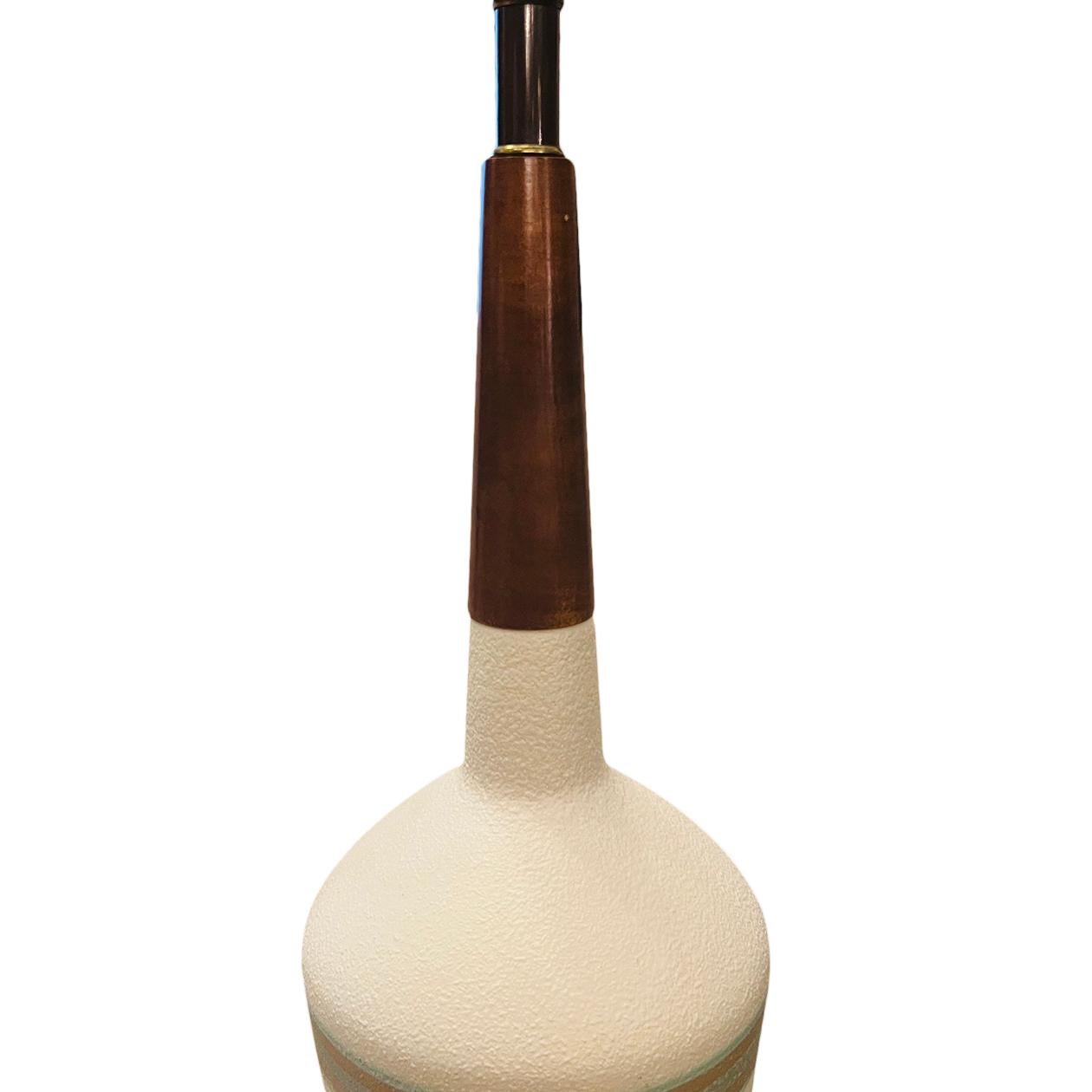 Coppia di lampade da tavolo in porcellana e legno degli anni '60 circa.

Misure:
Altezza della scocca: 22