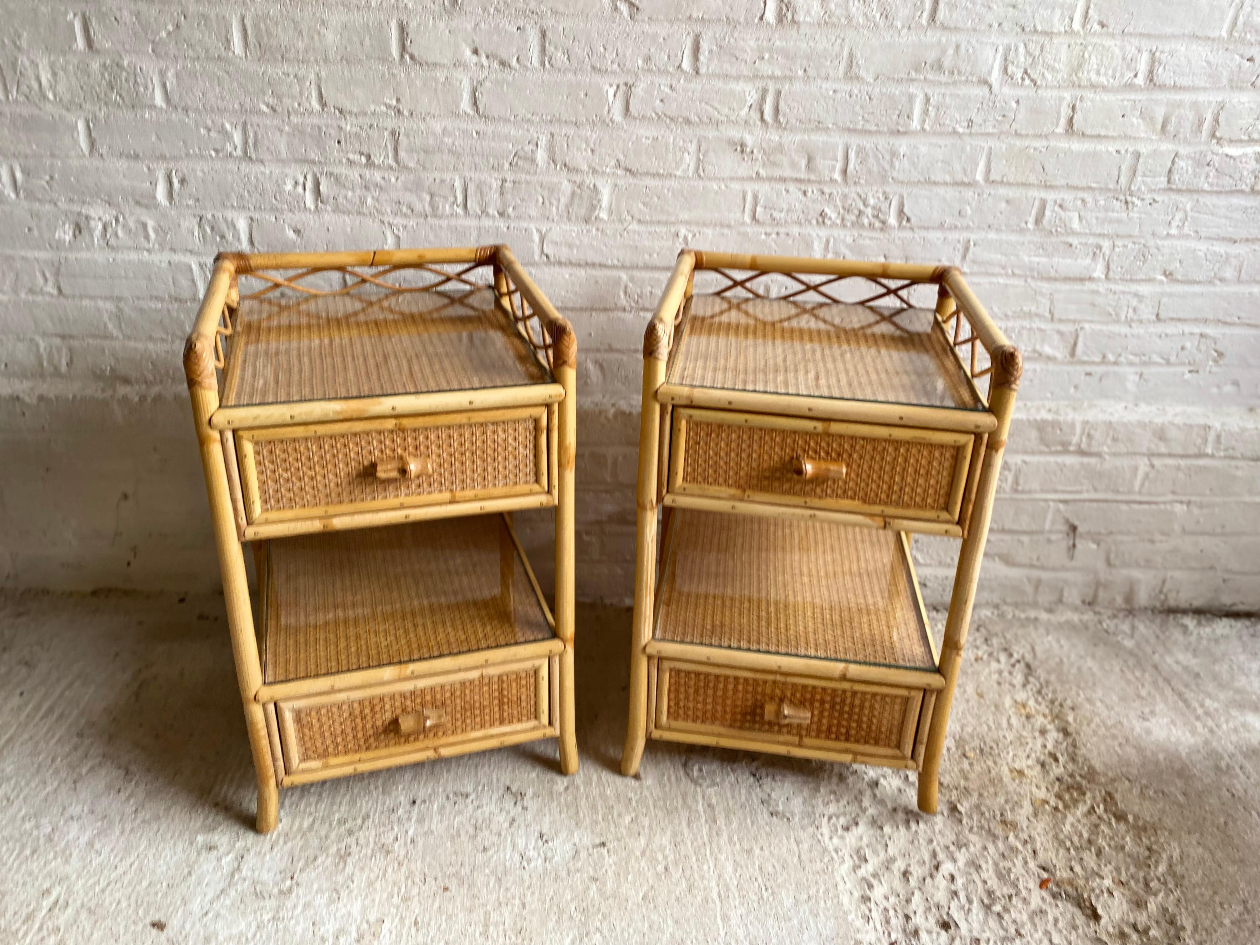 Pair of mid-century rattan / cane nightstands / bedside tables by English company, Angraves, England, 1970s.

Each nightstand has 2 x drawers with cane handles, with a void in between the two, they are covered in cane weave matting, and each have