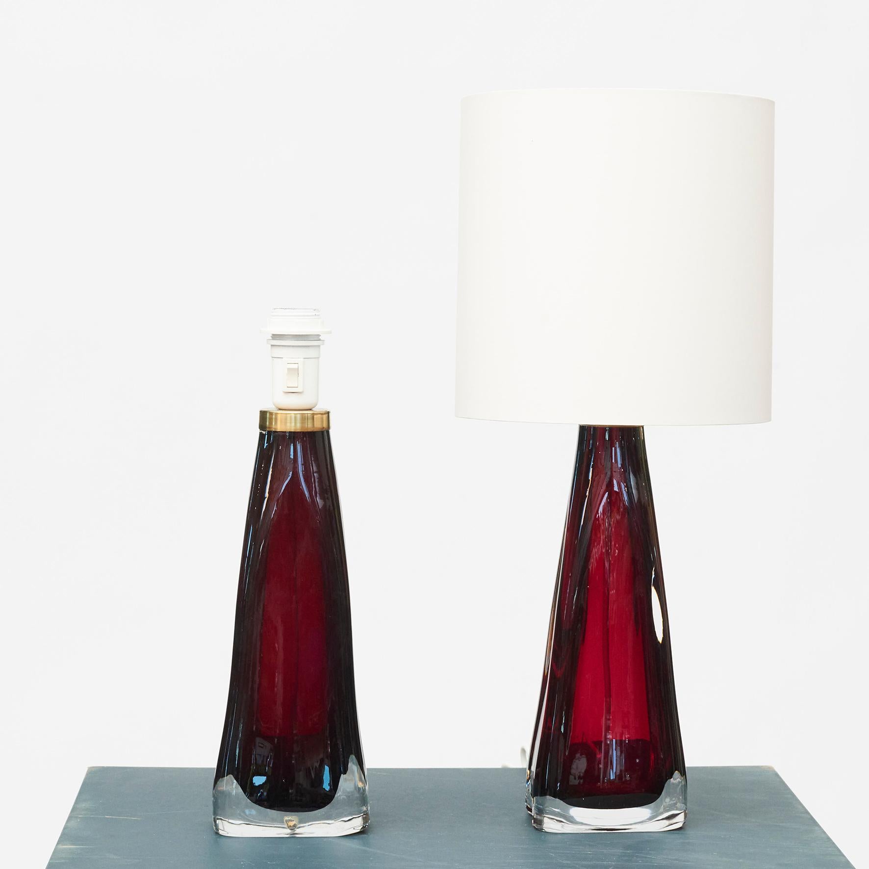 Pair of red glass table lamps by Carl Fagerlund (1915-2011) for Orrefors. 
Sweden approx. 1960.
Lampshades with blue-white fabric lining. 
Newly rewired and new socket.

Lamp: H: 41 - W: 12 - D: 8
Incl. shade: H: 57