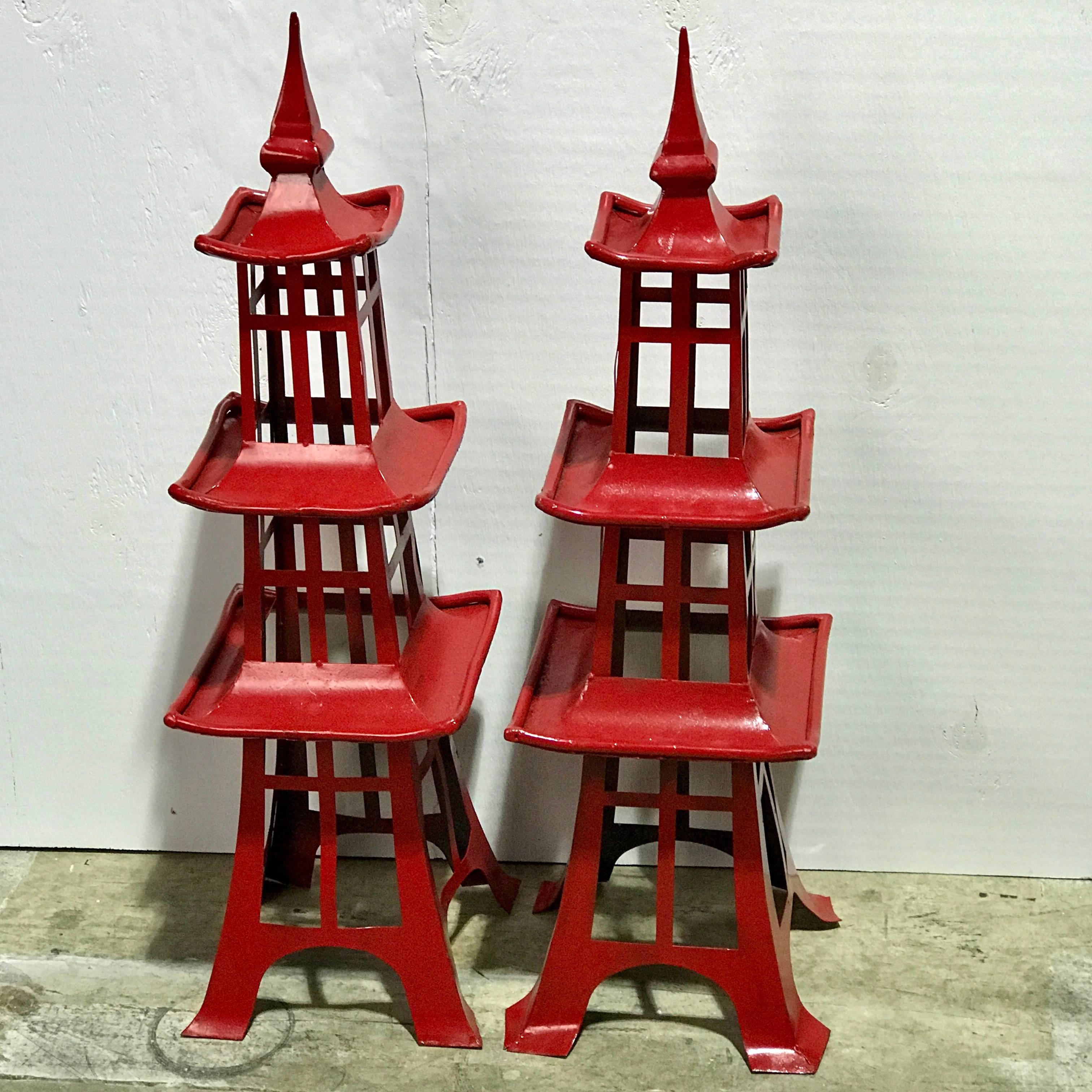 Pair of midcentury red enameled metal Japanese pagodas, from Walt Disney World. Each one a architectural model, with red enameled tiered pierced bodies.