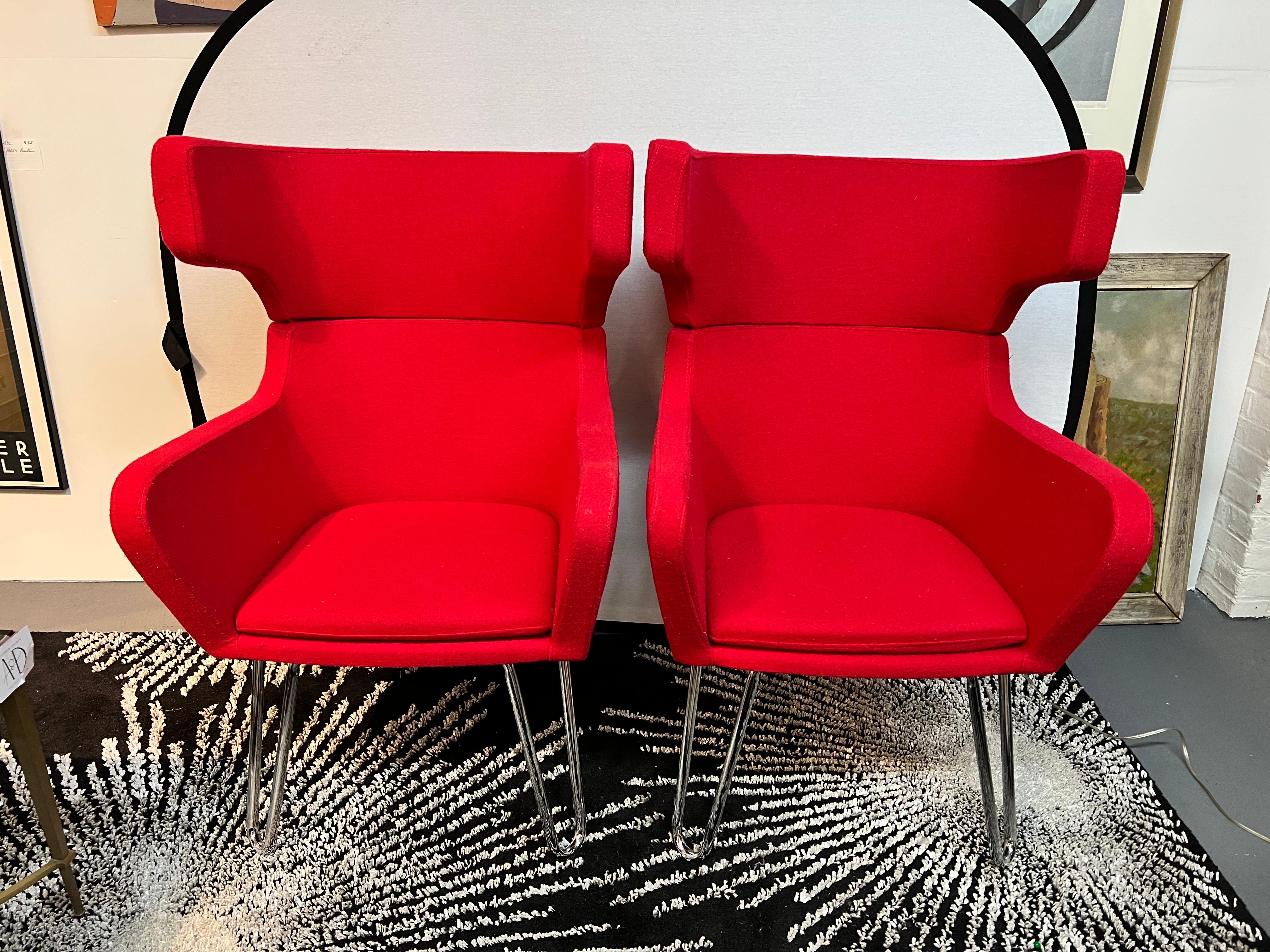 Pair of mid century Ox chairs. These are reproductions and well done with vibrant red synthetic fabric and hairpin legs. A gorgeous set.