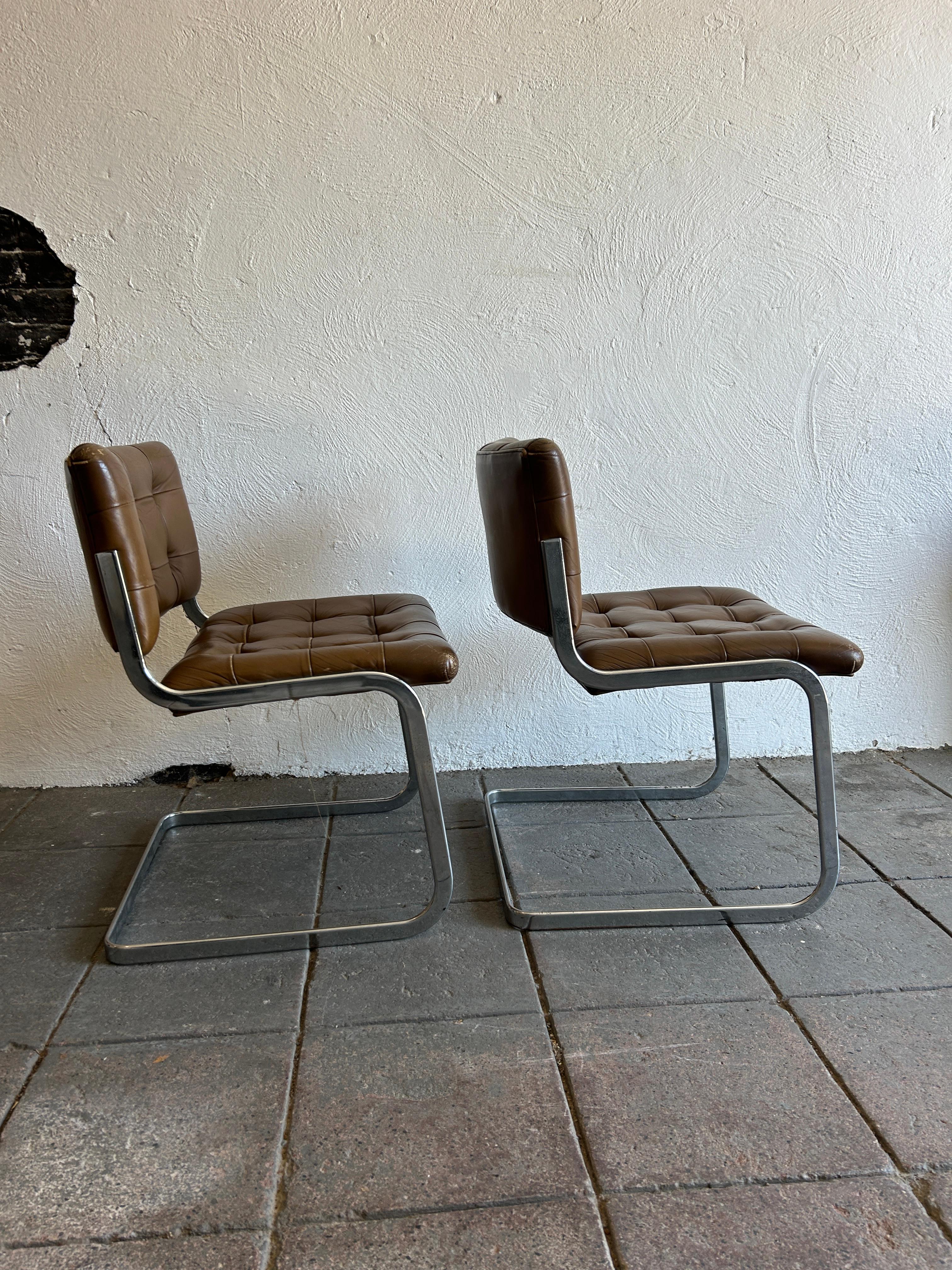 A unique pair of RH-304 Leather chairs. designed by Robert Haussmann and manufactured by Stendig De Sede. This pair was made circa 1960. these chairs are upholstered in brown leather. The rounded flat bar tube frames are made of chrome-plated steel.